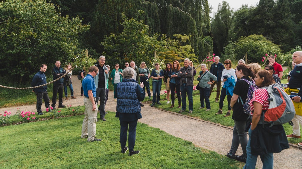 National Trust Council members standing in a garden listening to someone do a talk
