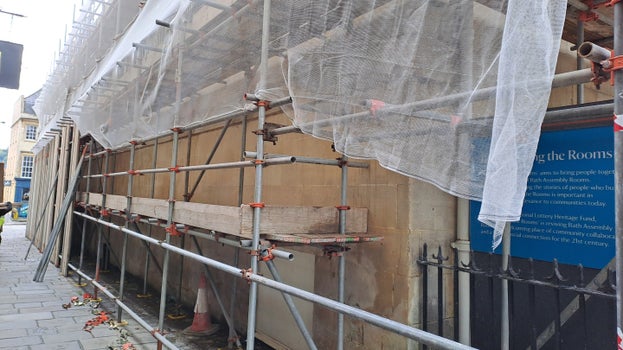 Parts of the scaffolding have been removed with planks, poles and connectors stacked on the floor near the remaining scaffold as it gets ready to come down.