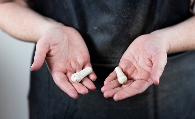 A pair of hands palm up holding the remains of a wig curler in each palm