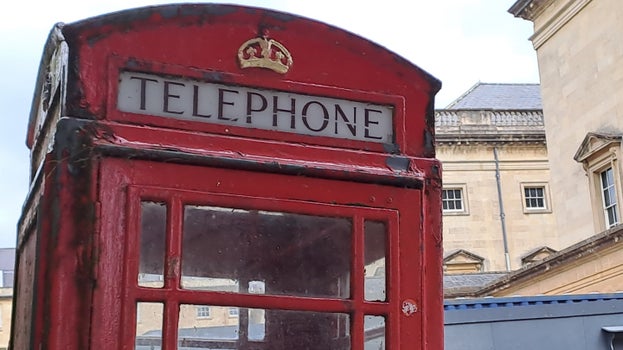 A close-up of the top of the red telephone box on the courtyard outside Bath Assembly Rooms