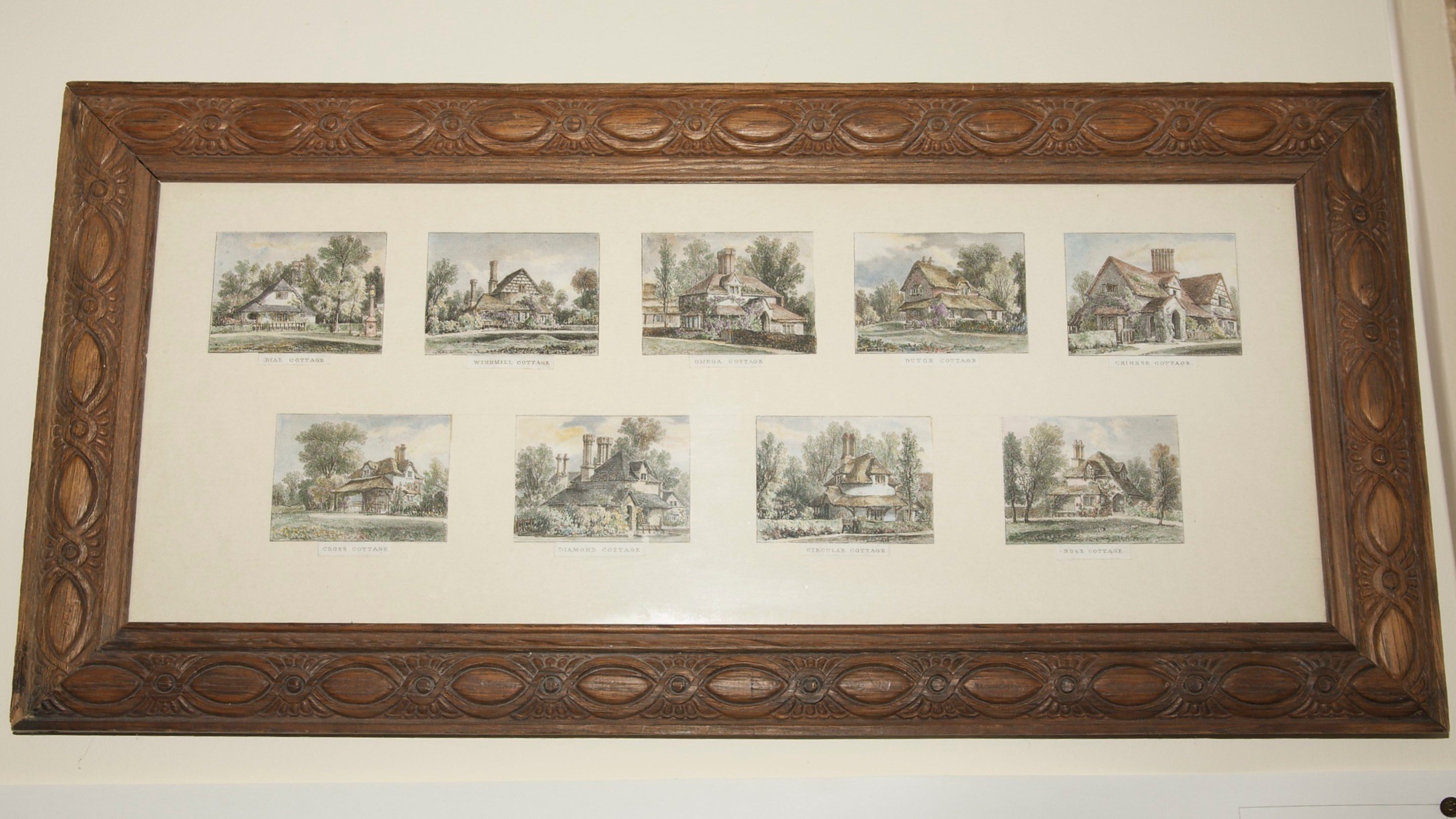 A wooden frame containing a series of nine small hand coloured lithographs of the cottages at Blaise Hamlet, Bristol