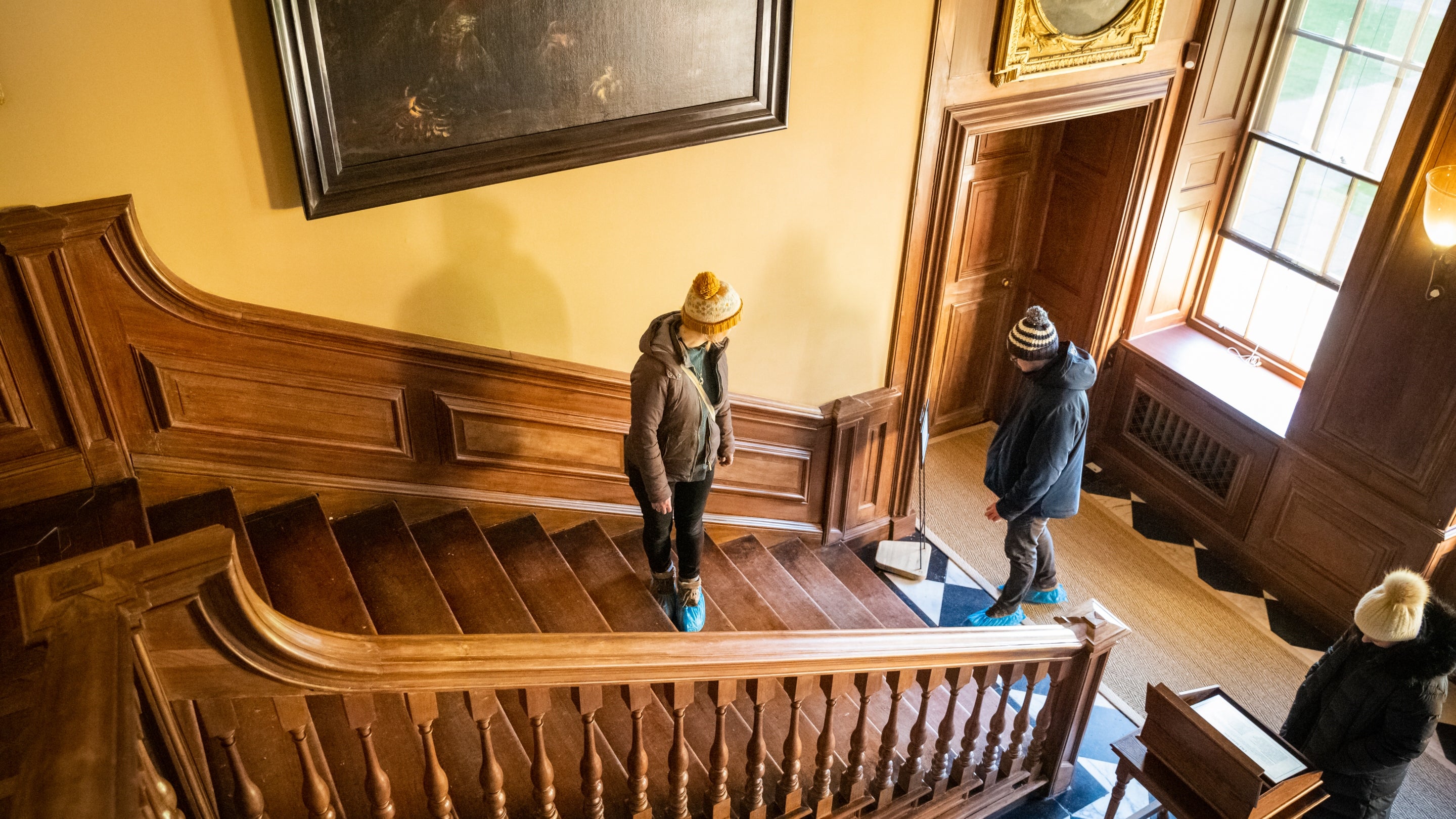 A couple in winter hats on the Old Staircase at Dyrham Park, South Gloucestershire