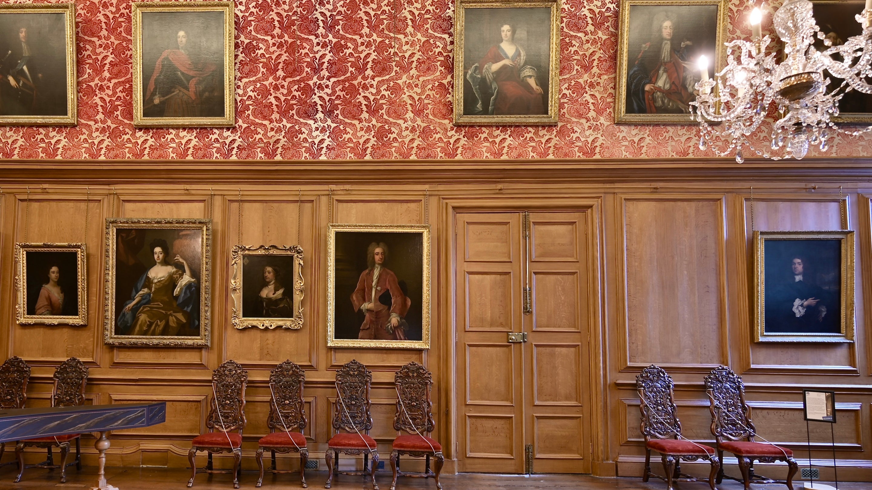 Chairs, pictures and a chandelier in the Great Hall at Dyrham Park