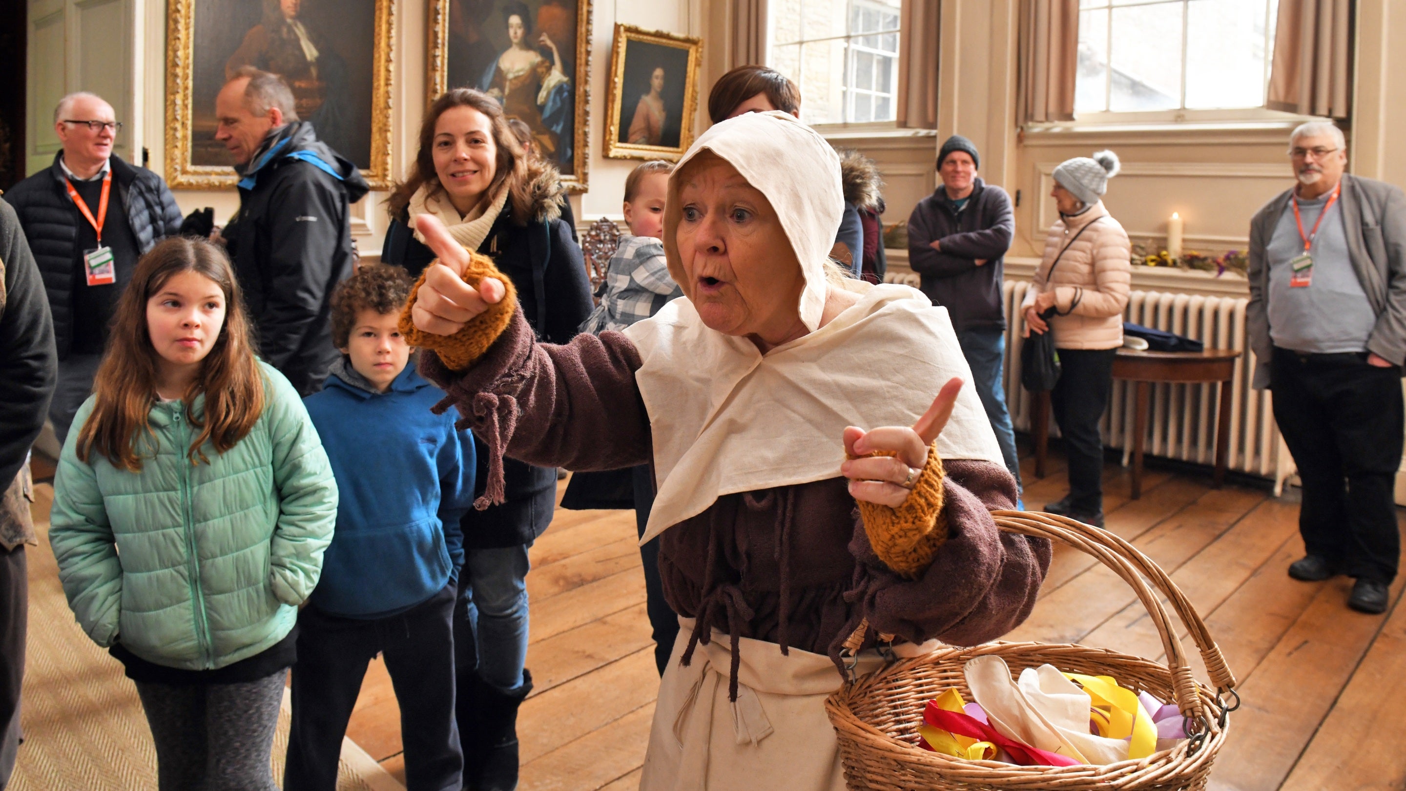A volunteer wearing historical costume leads visitors around a traditional 17th-century Christmas trail at Dyrham Park, Gloucestershire