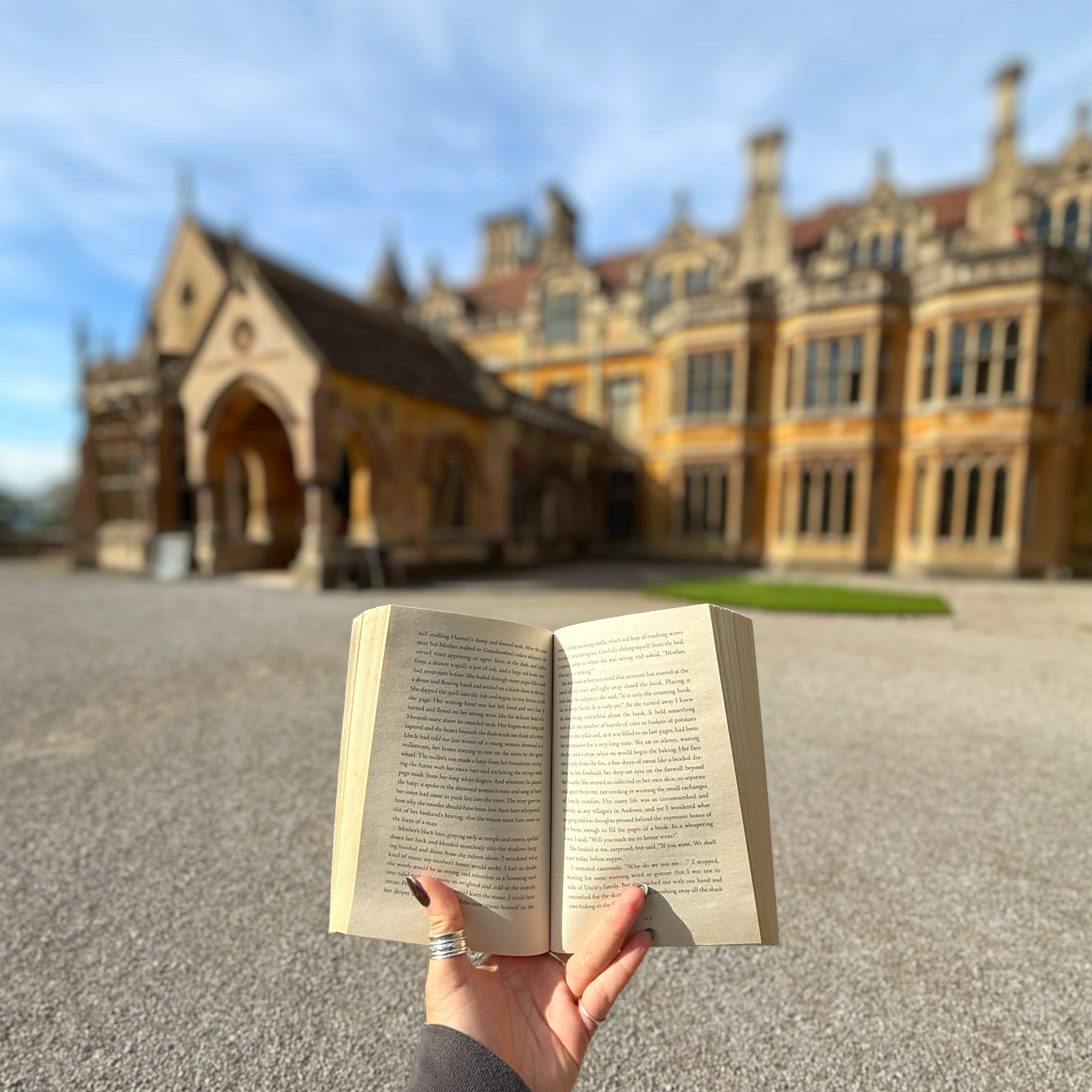 A person holiday a book open in front of Tyntesfield House.
