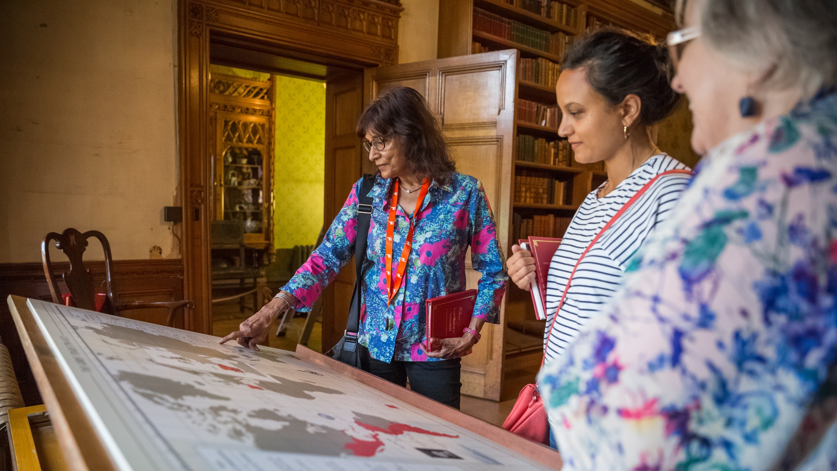 Two visitors and volunteer looking at a map at Tyntesfield, Somerset