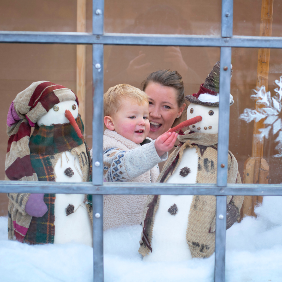A mother and child enjoy Christmas decorations in Tyntesfield's Orangery
