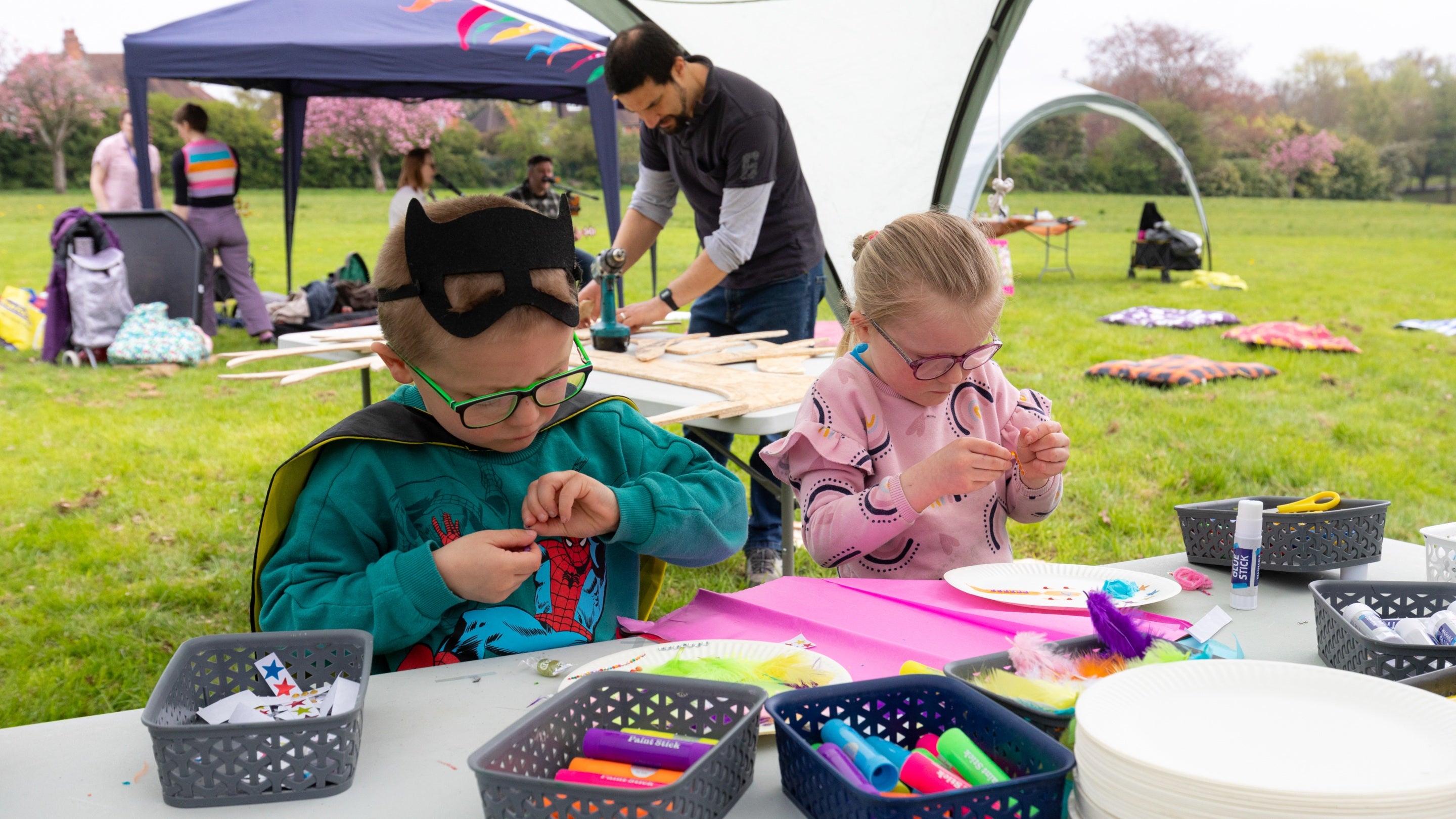 Two children at a craft table in a park in Birmingham on a spring day
