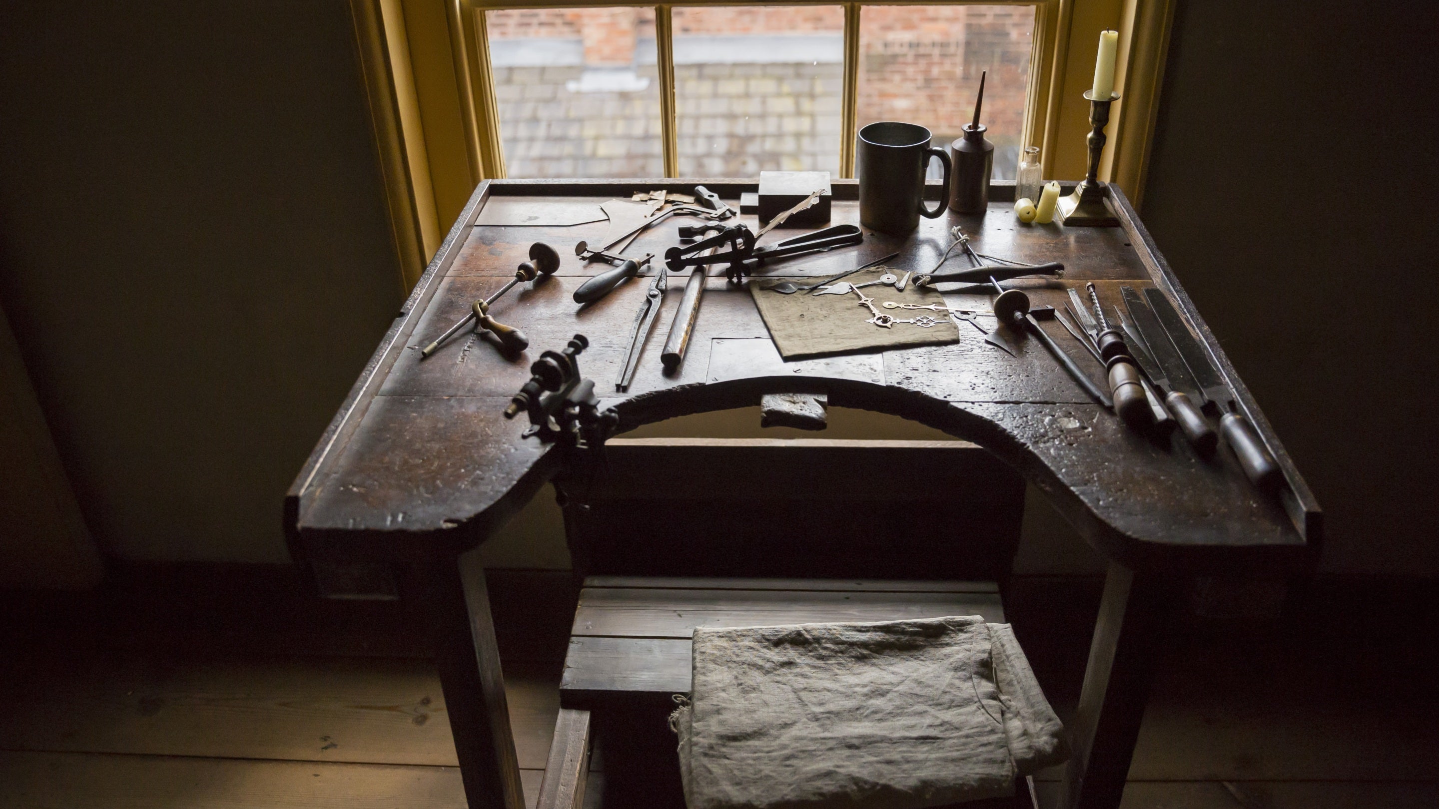 A small worktable positioned by a window covered with a watchmaker's tools at the Birmingham Back to Backs, West Midlands.