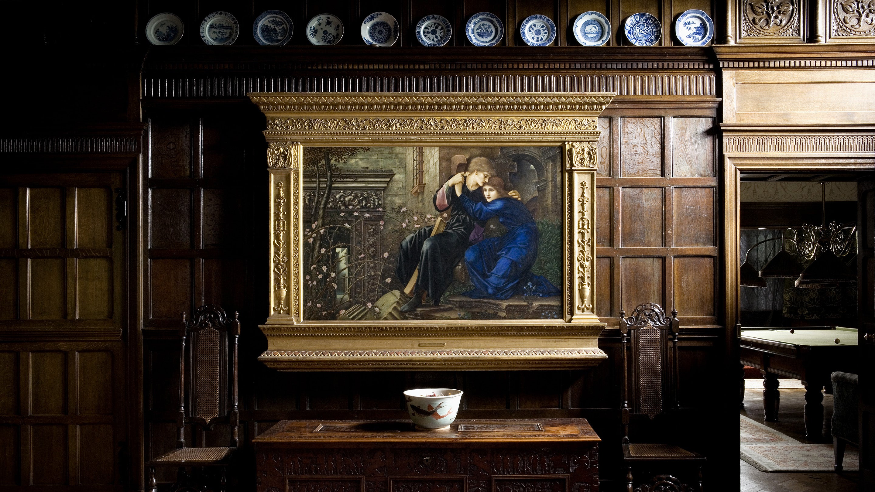The painting Love among the Ruins, by Sir Edward Coley Burne-Jones (1833-1898), 1894, hangs against the oak panelling of the Great Parlour at Wightwick Manor