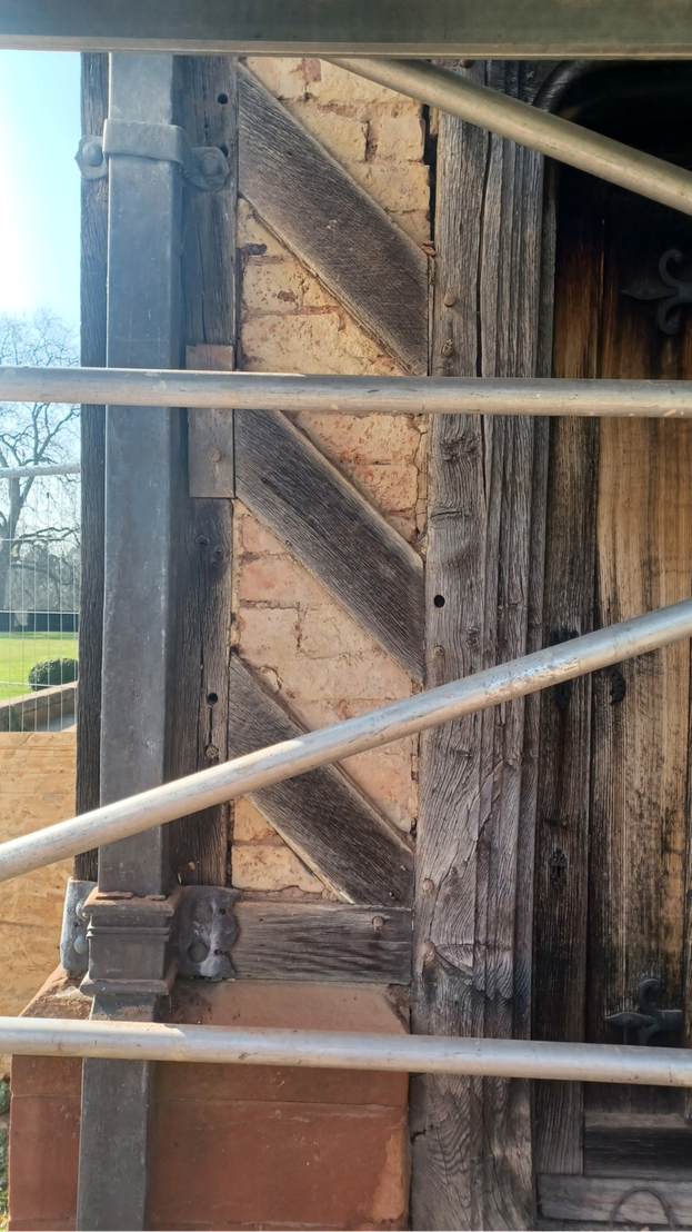 Looking towards the outside of the Billiard Room door at Wightwick Manor, the lime rendering has been removed from between the oak beams to reveal the old brick work underneath.