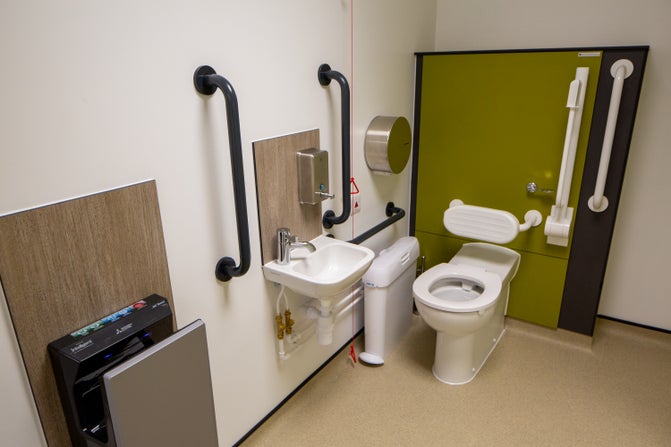 Accessible toilet with rails, low sink and hand dryer, emergency chord and plenty of space.