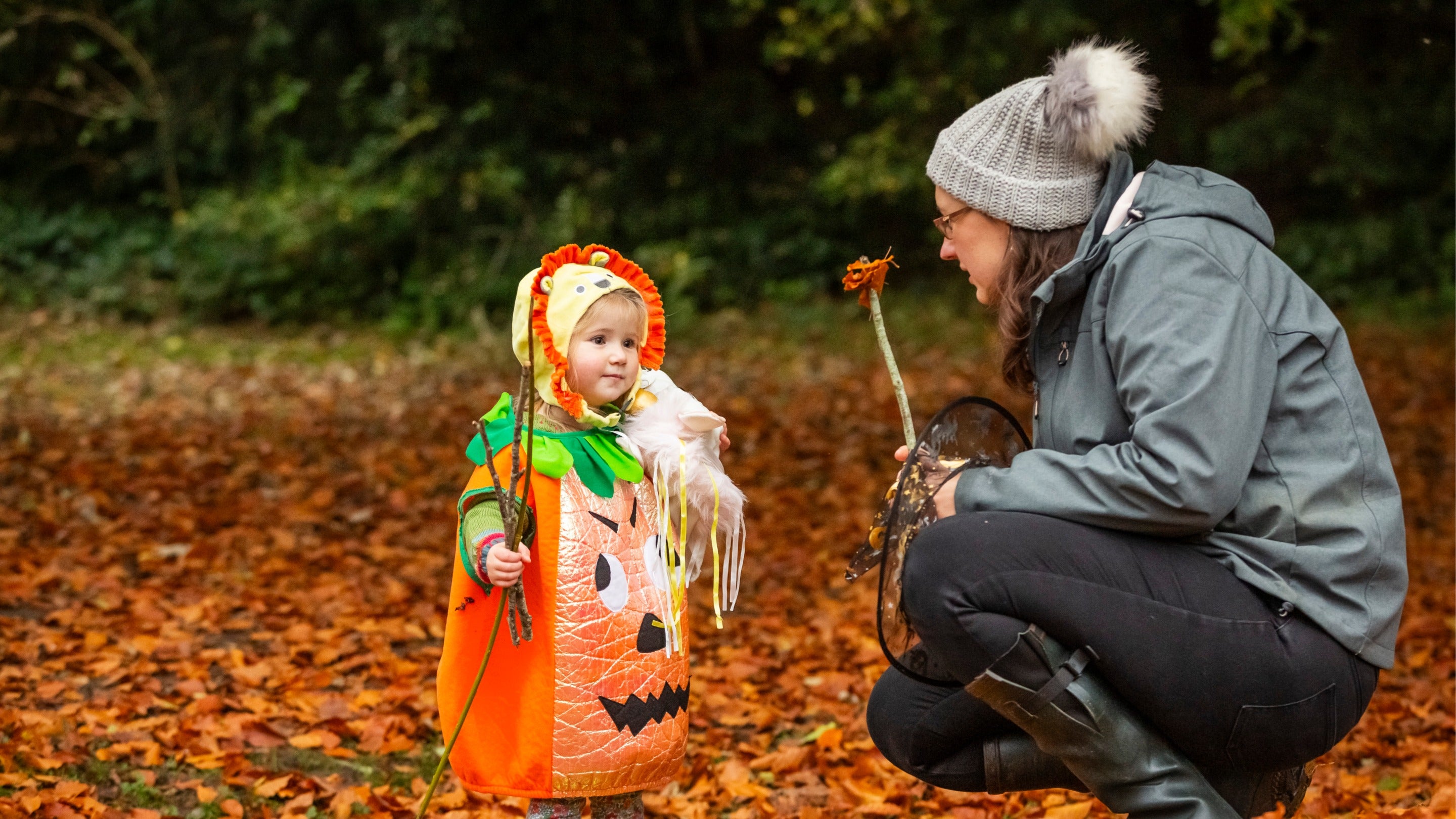 A child dressed in a pumpkin costume for Halloween at Anglesey Abbey, Cambridgeshire