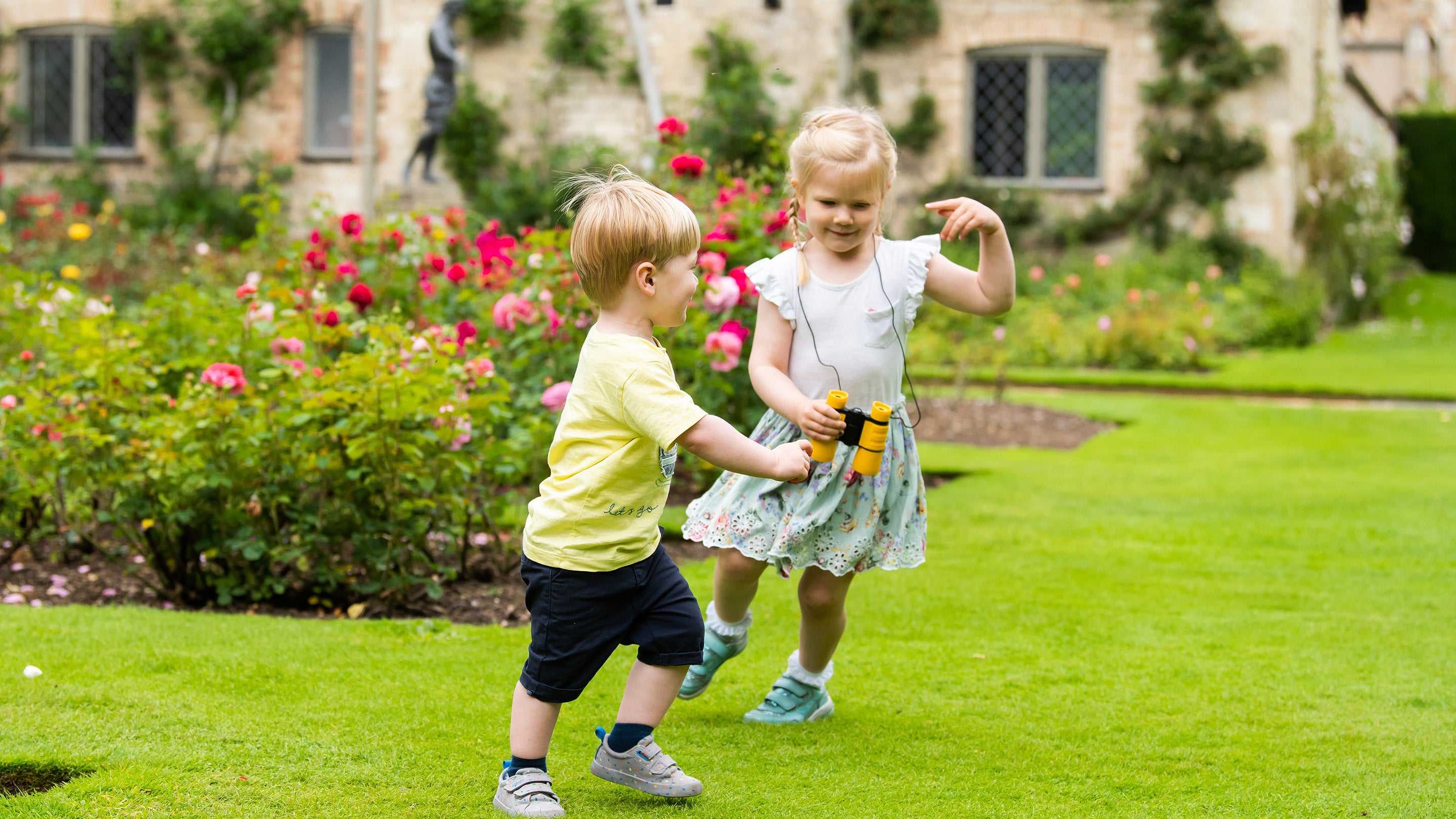 Two playing in the garden in summer at Anglesey Abbey, Cambridgeshire