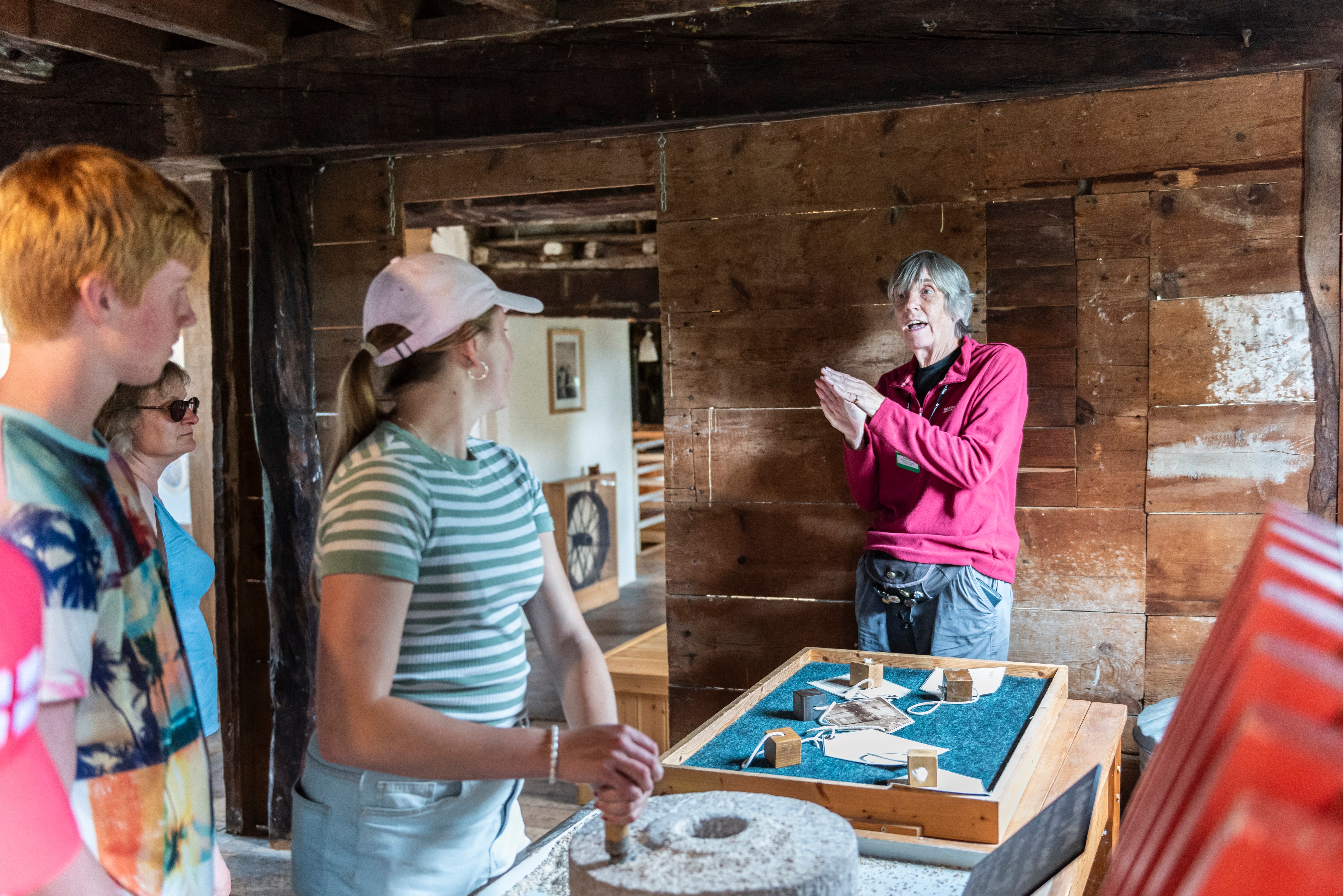 Visitors engaging with Volunteer guide inside Houghton Mill