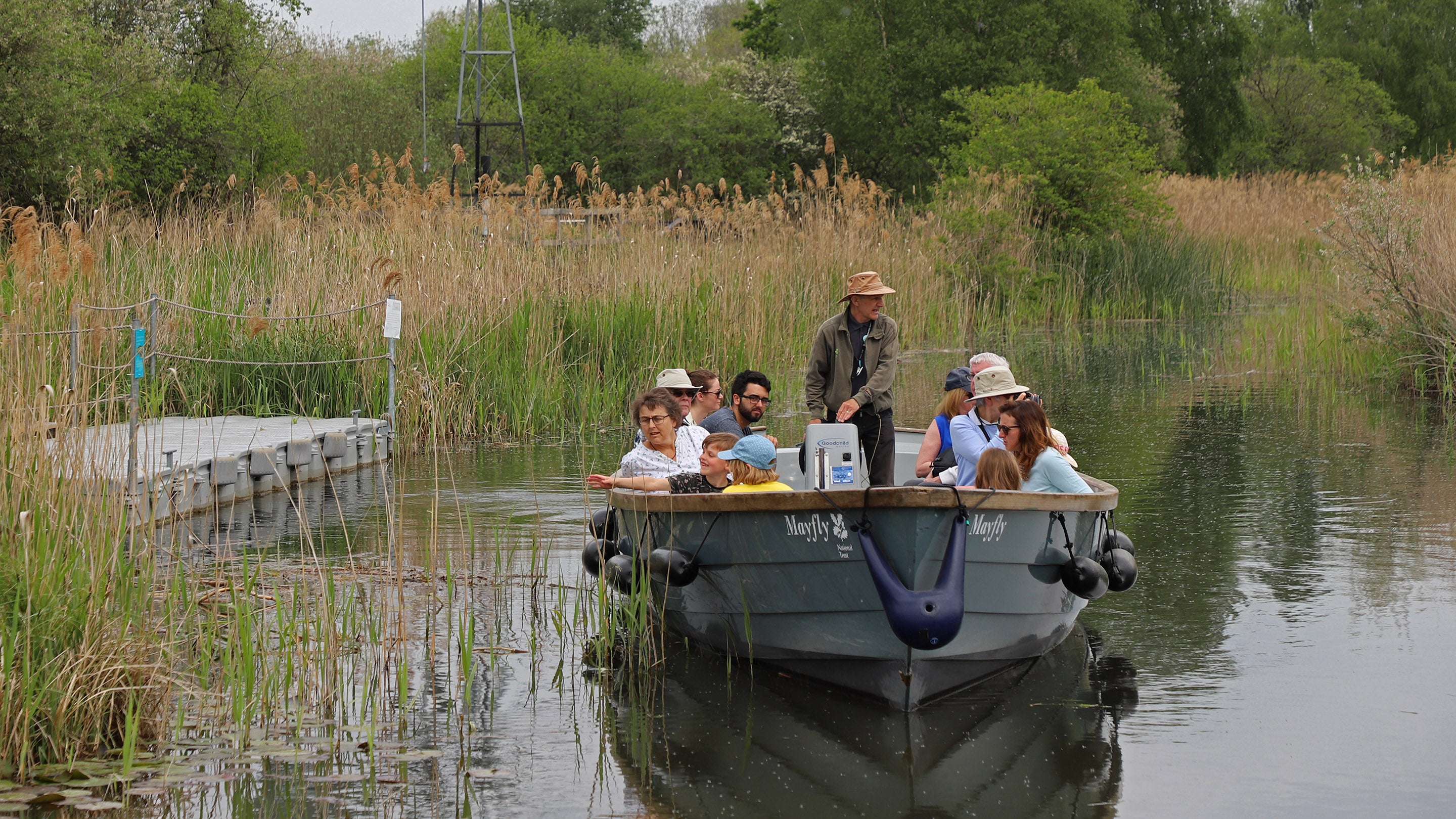 Visitors on a boat trip at Wicken Fen National Nature Reserve, Cambridgeshire