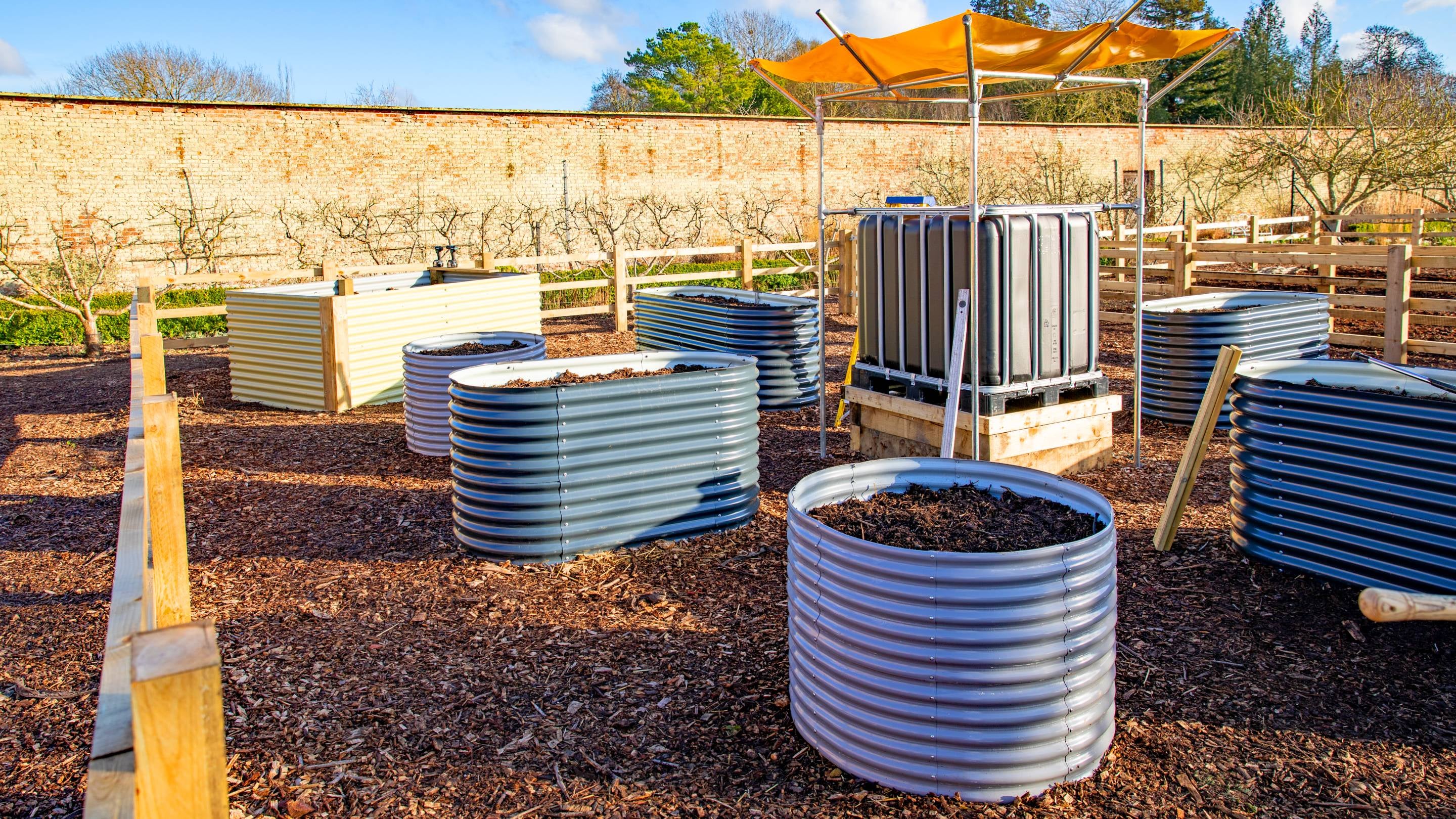 Eight large containers in the walled garden one has an orange shade over the top