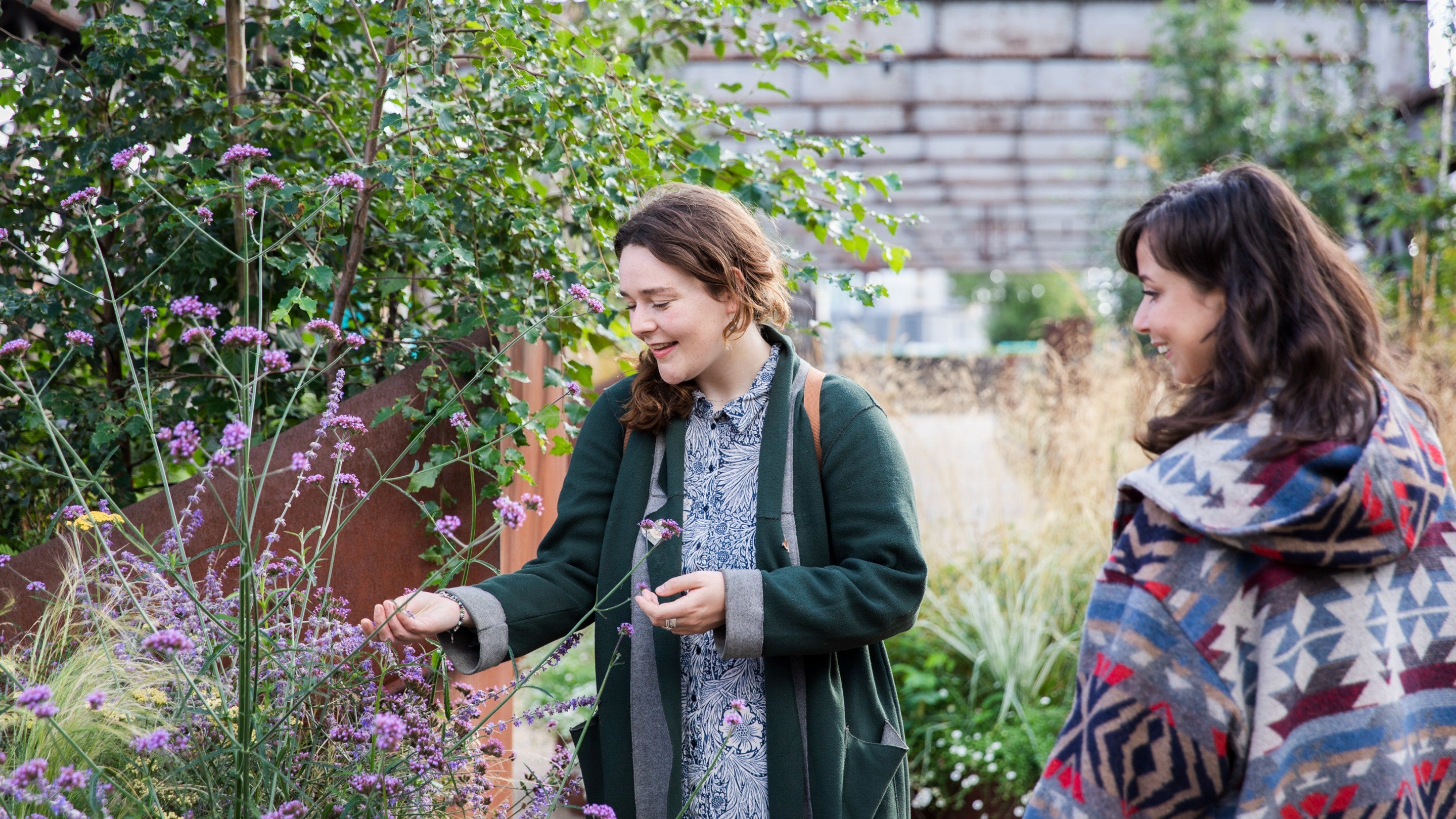 Two friends looking at the planted flowers at the temporary urban park at Castlefield Viaduct, Manchester