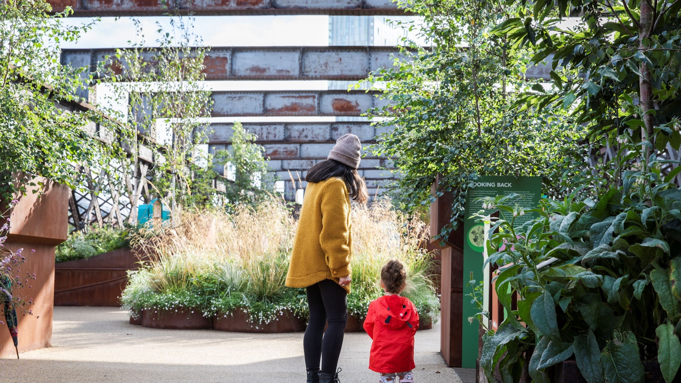 A parent and child wearing colourful coats explore Castlefield Viaduct.