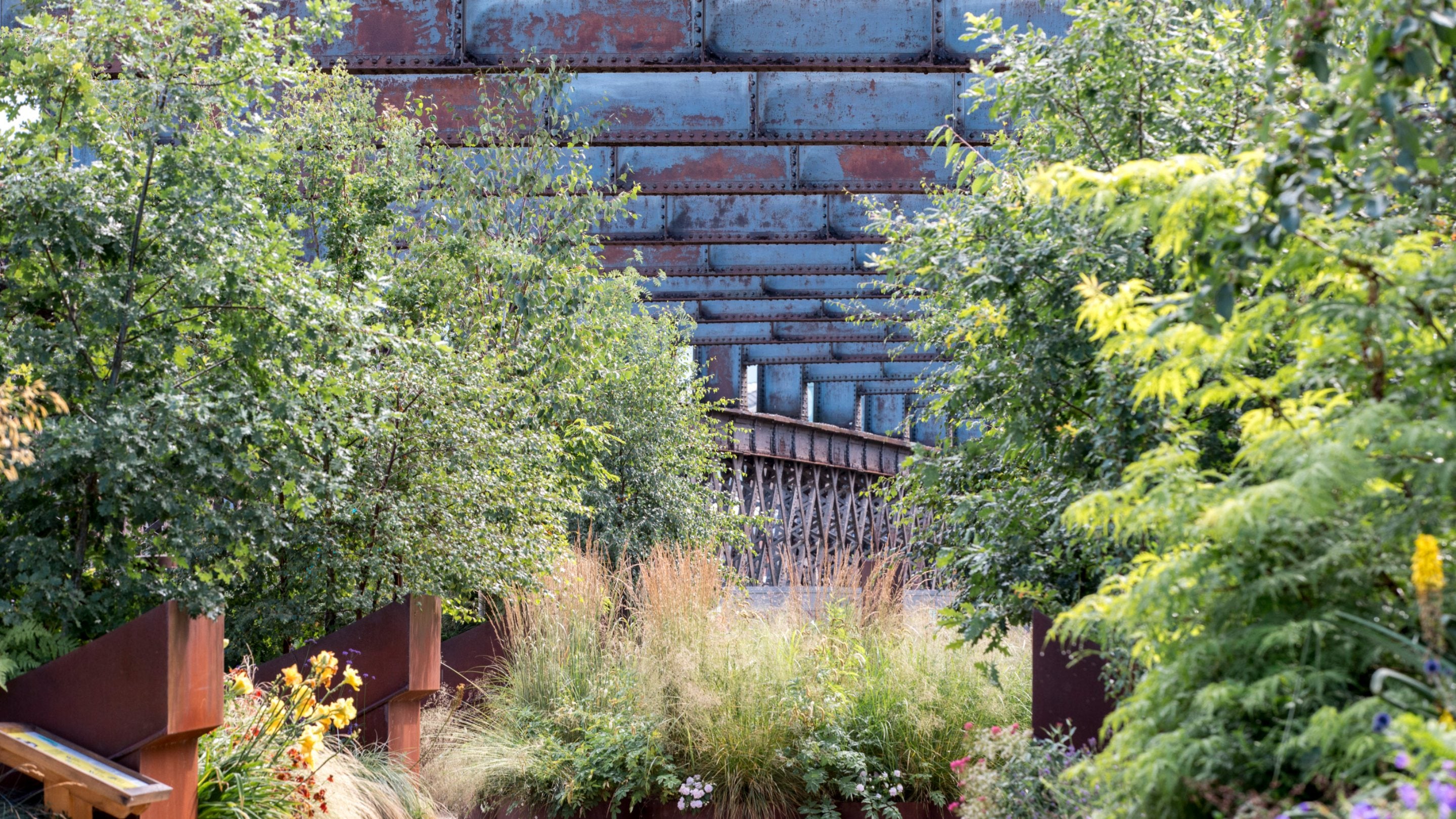 View of tree planting and steel structure at Castlefield Viaduct, Manchester