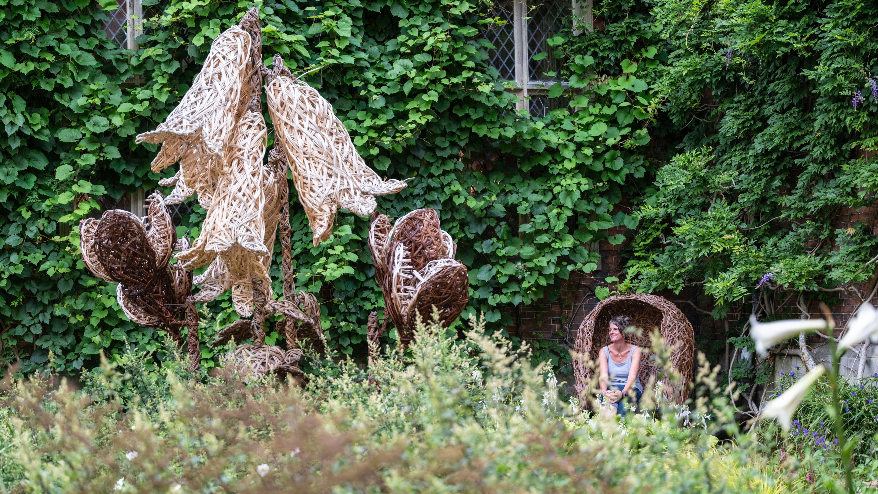 A visitor sat in the house courtyard and surrounded by giant Himalayan lilies.