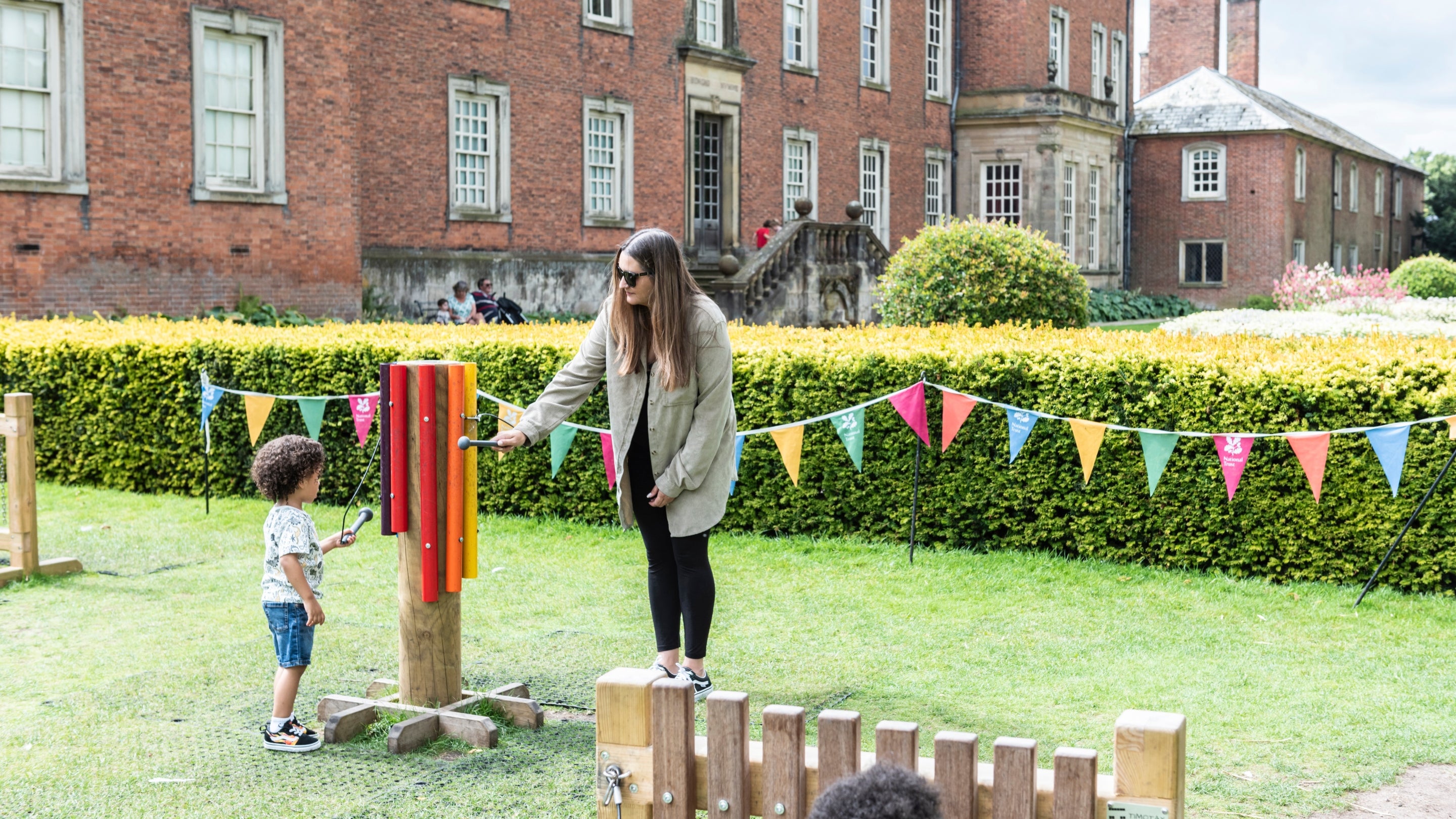 A family playing with giant musical instruments at Dunham Massey, Cheshire.