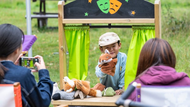 A family enjoying roleplaying games in the North Park during Summer of Play at Dunham Massey, Cheshire