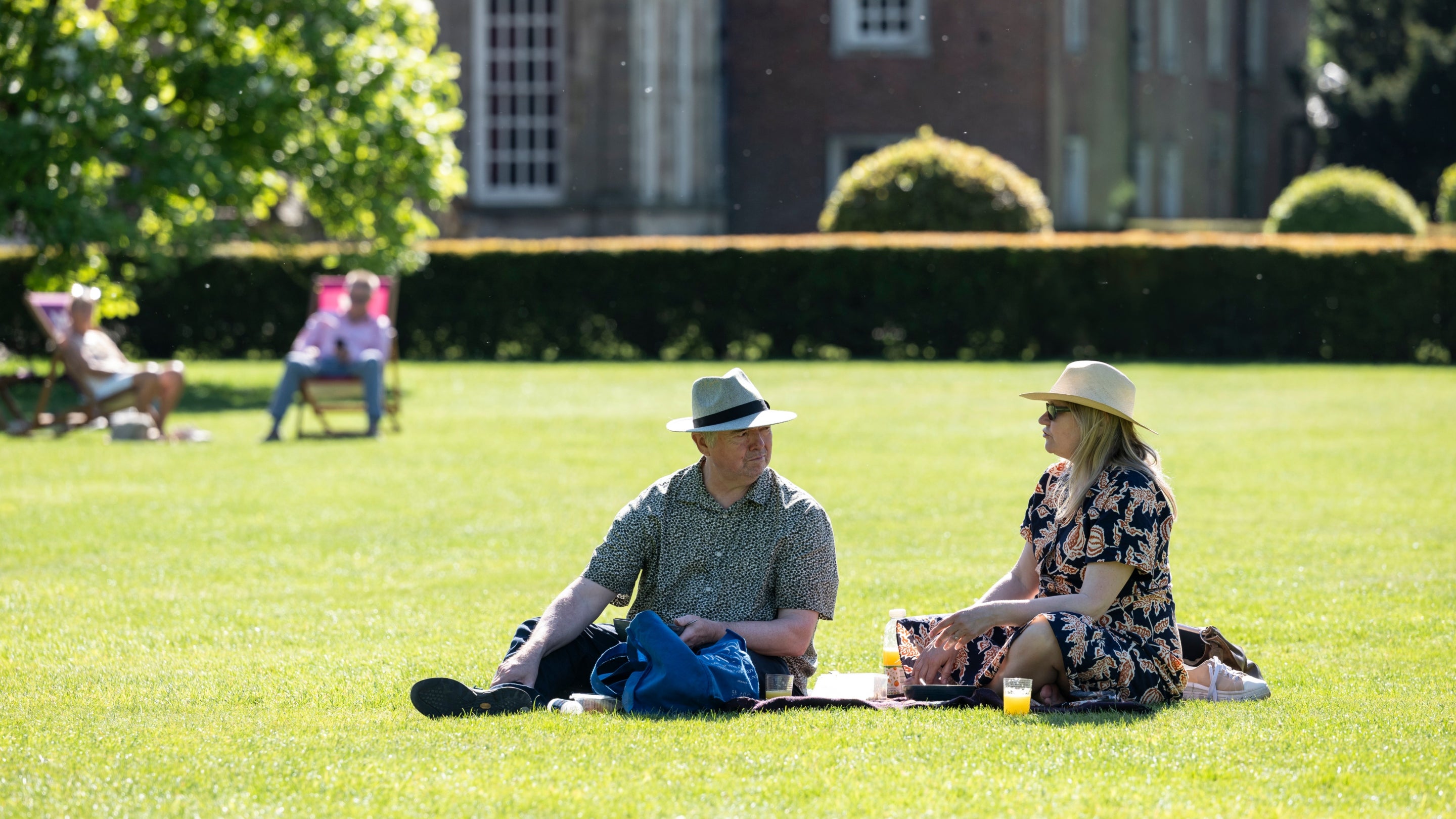 Visitors enjoying a picnic on the lawn at Dunham Massey, Cheshire