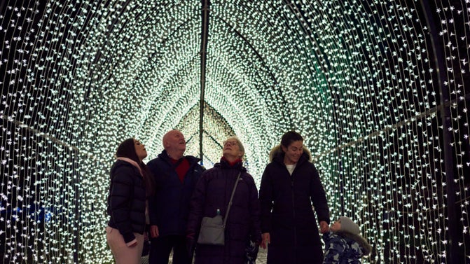 Visitors enjoying the illuminated Christmas trail in the park at Dunham Massey, Cheshire