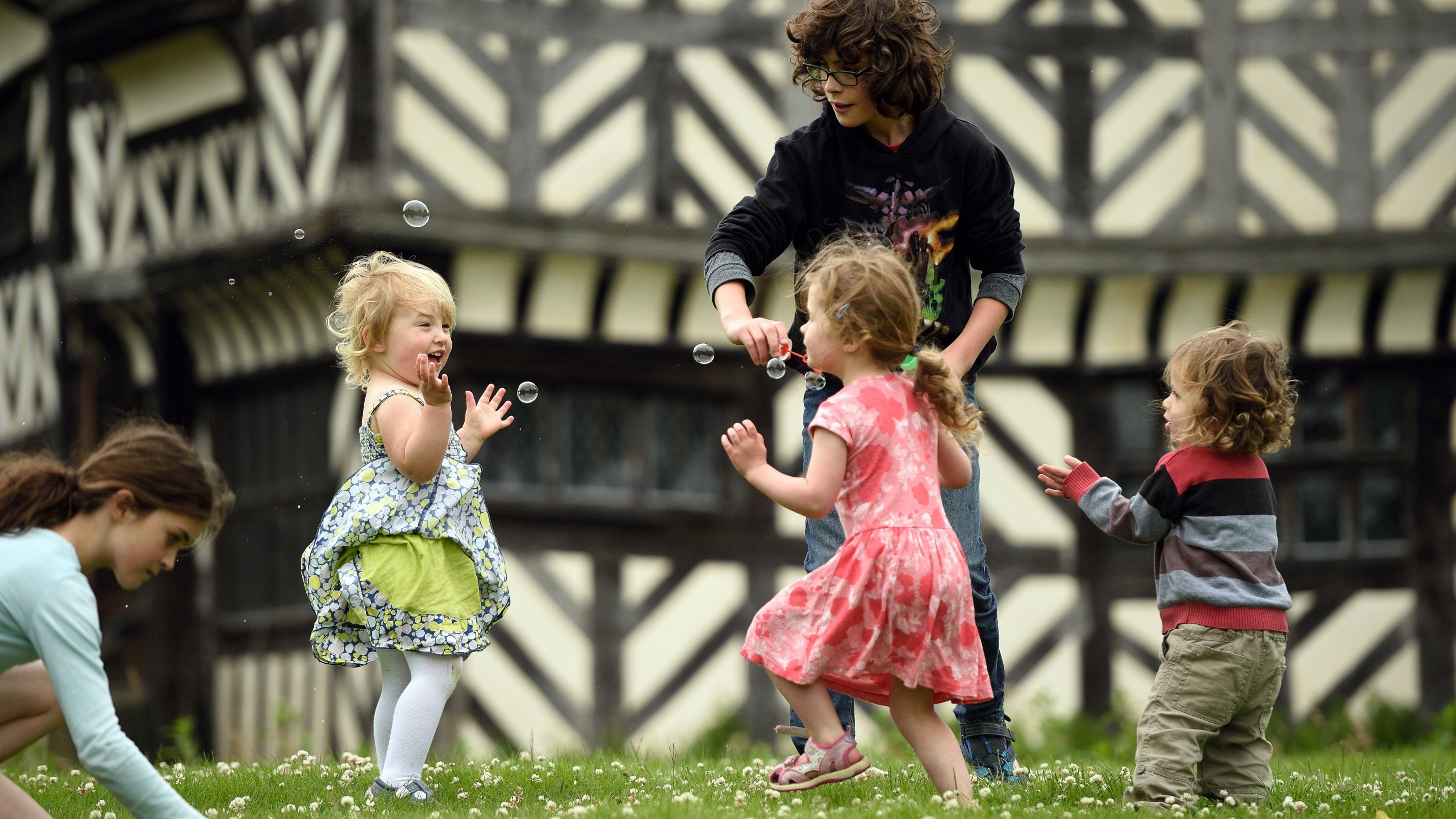Children playing on the lawn at Little Moreton Hall, Cheshire