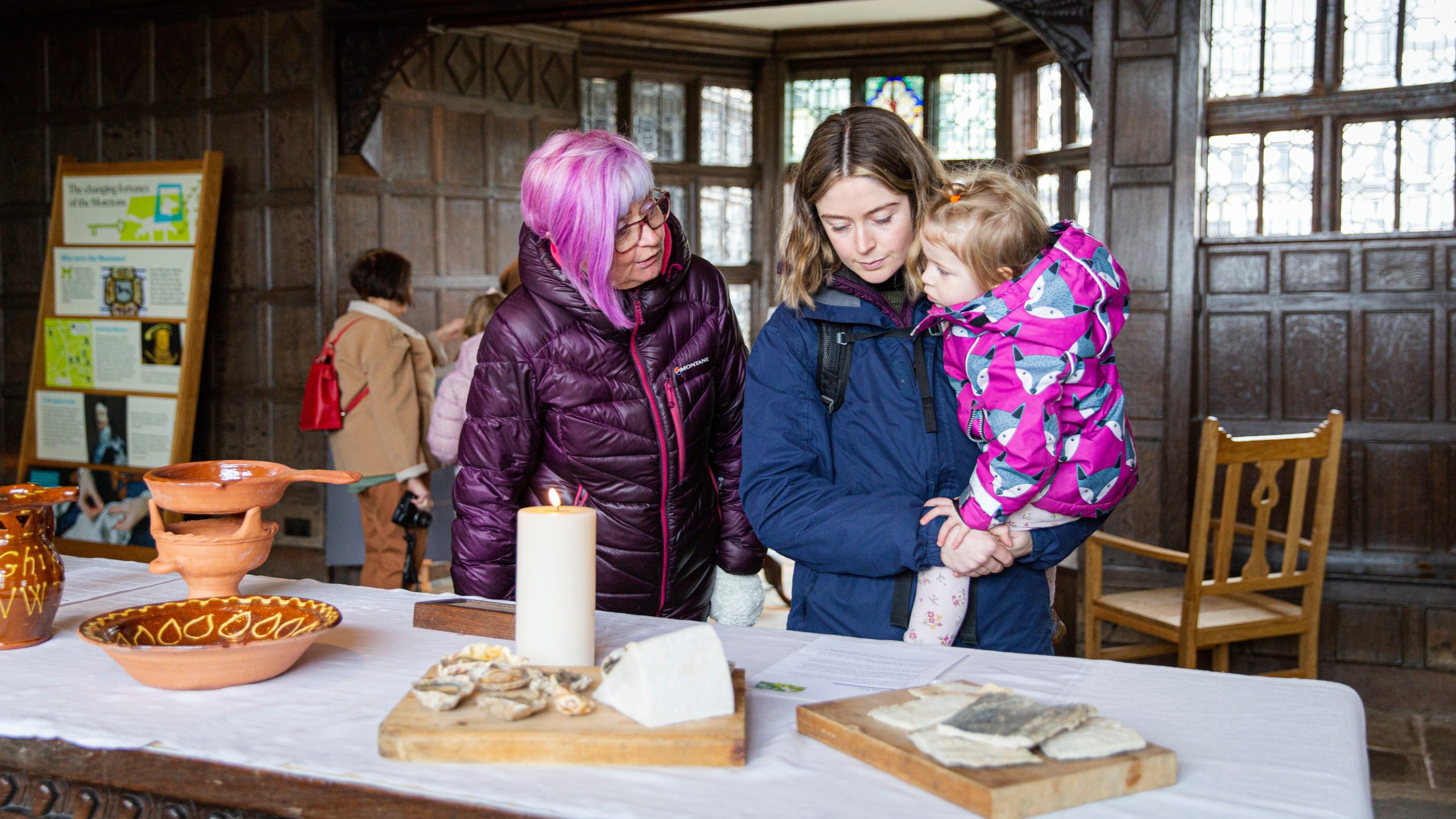 A family exploring the Tudor way of living inside the manor house at Little Moreton Hall, Cheshire