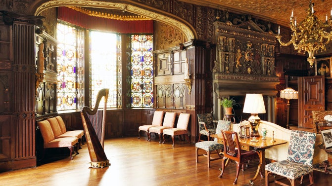 A harp stands in a well lit ornate room at Lyme.