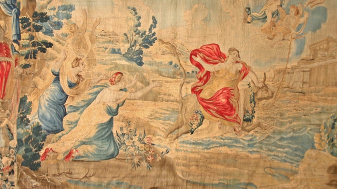 A women in a red dress is taken away by a bull as depicted on a woven tapestry.