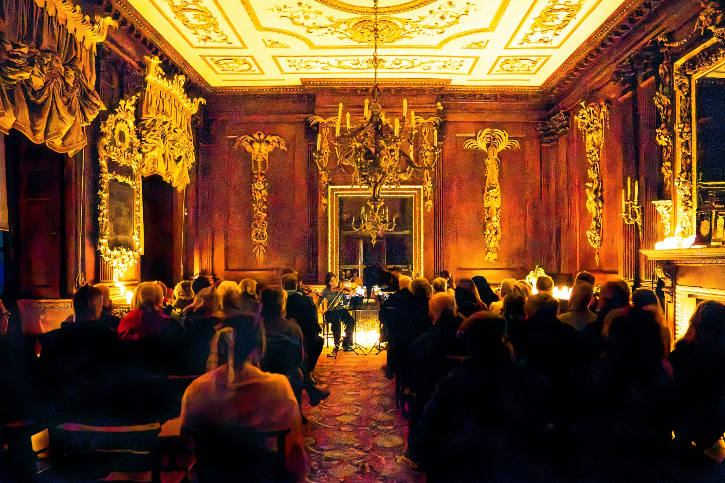 A concert in the Saloon at Lyme, lit by dozens of flickering candles.