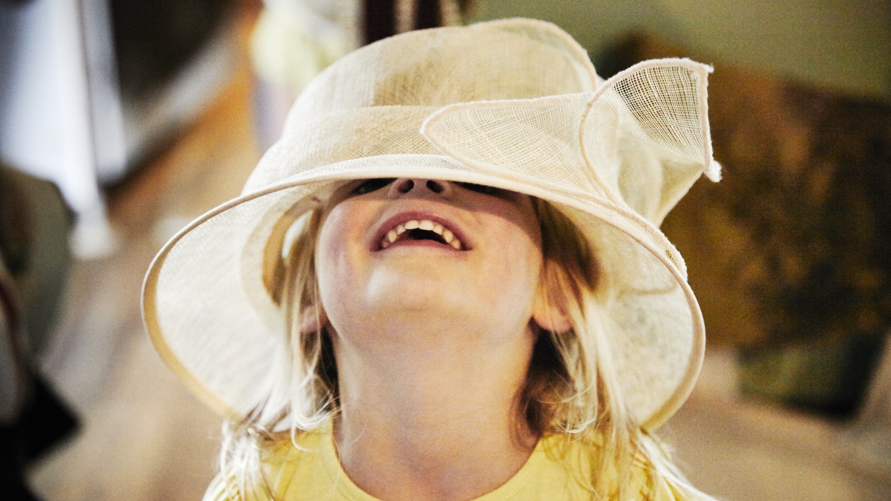 A close up of a girl in a recency style sun hat.