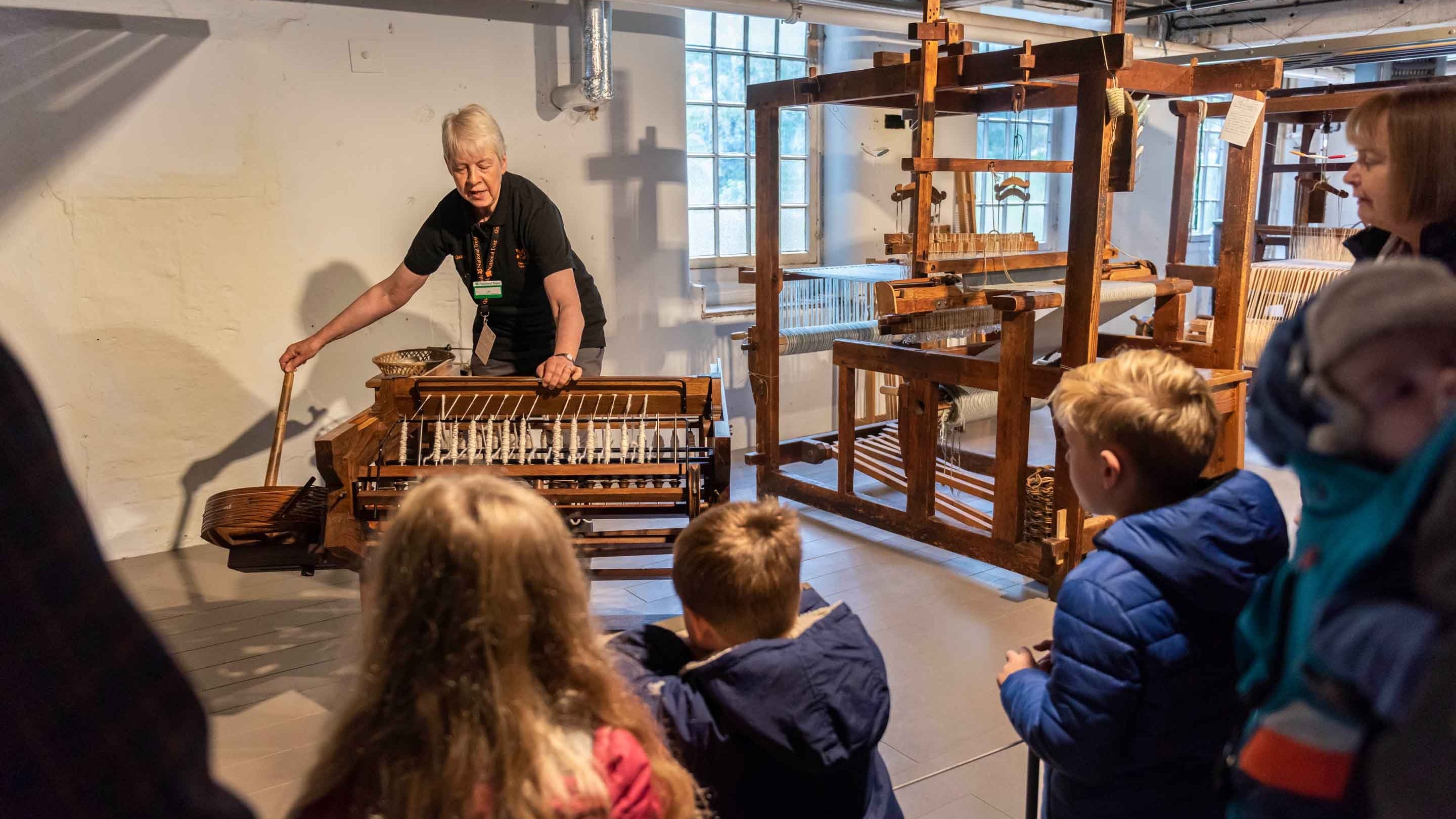 Volunteer demonstrating a loom to visitors at Quarry Bank Mill, Cheshire