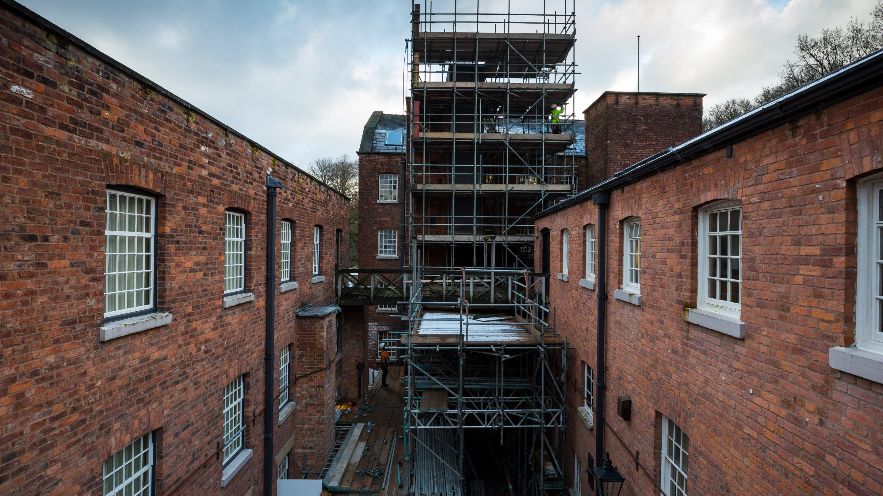 Essential maintenance work on the exterior of Quarry Bank Mill, Cheshire showing scaffold built against the exterior wall.