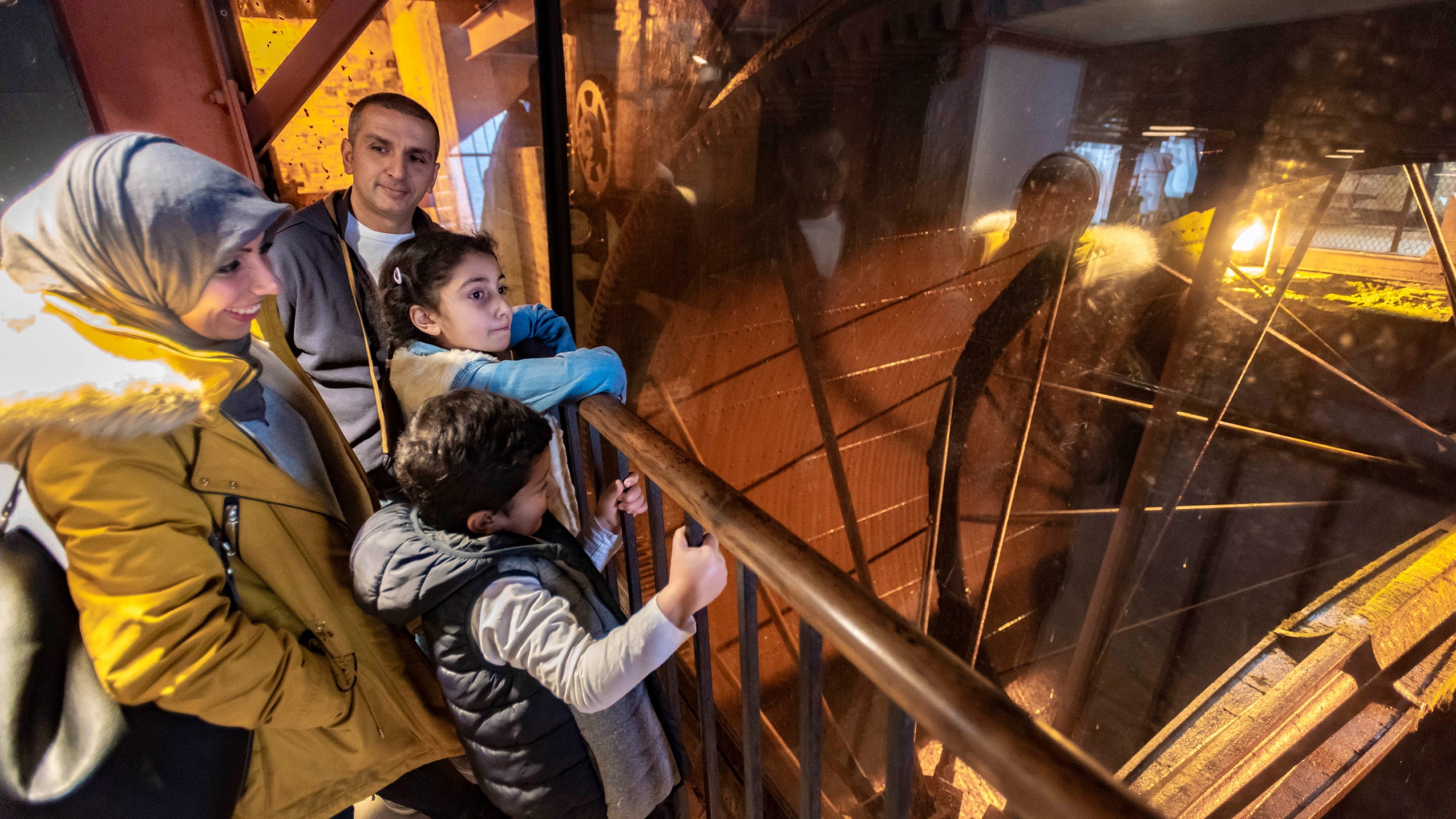 Four visitors looking at the water wheel at Quarry Bank, Cheshire