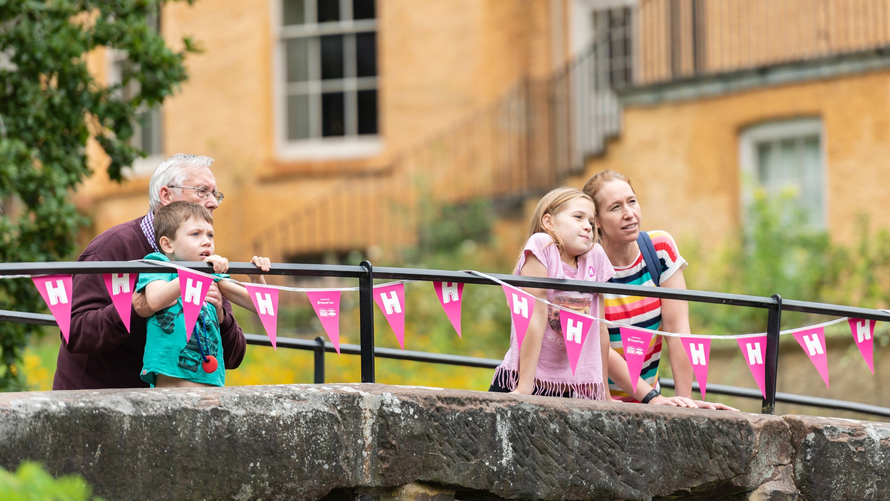 Visitors standing on a bridge looking over the side