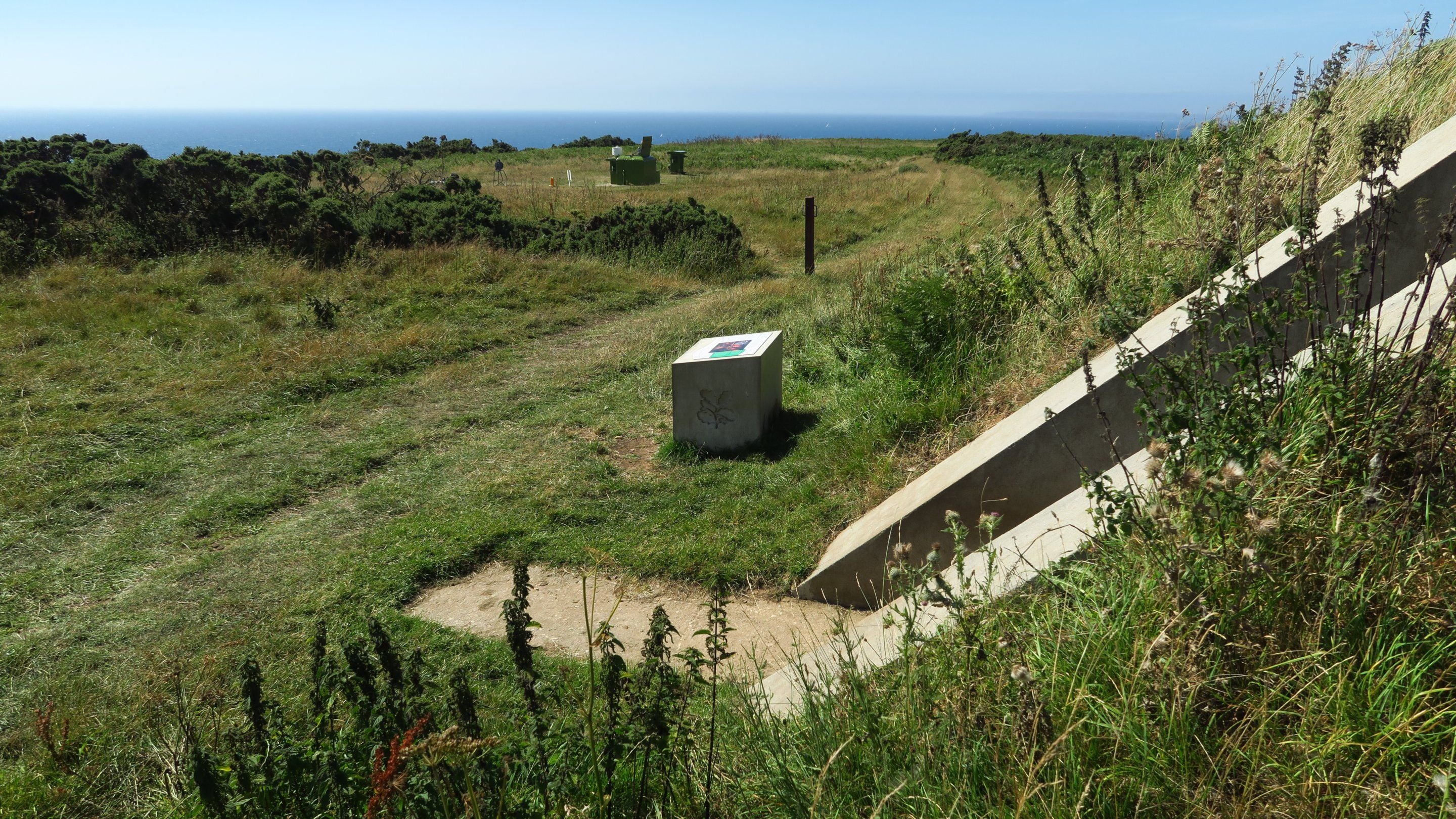 View of the Starfish decoy bunker with the ROC Veryan bunker in the distance, Nare Head, near Veryan in Cornwall.