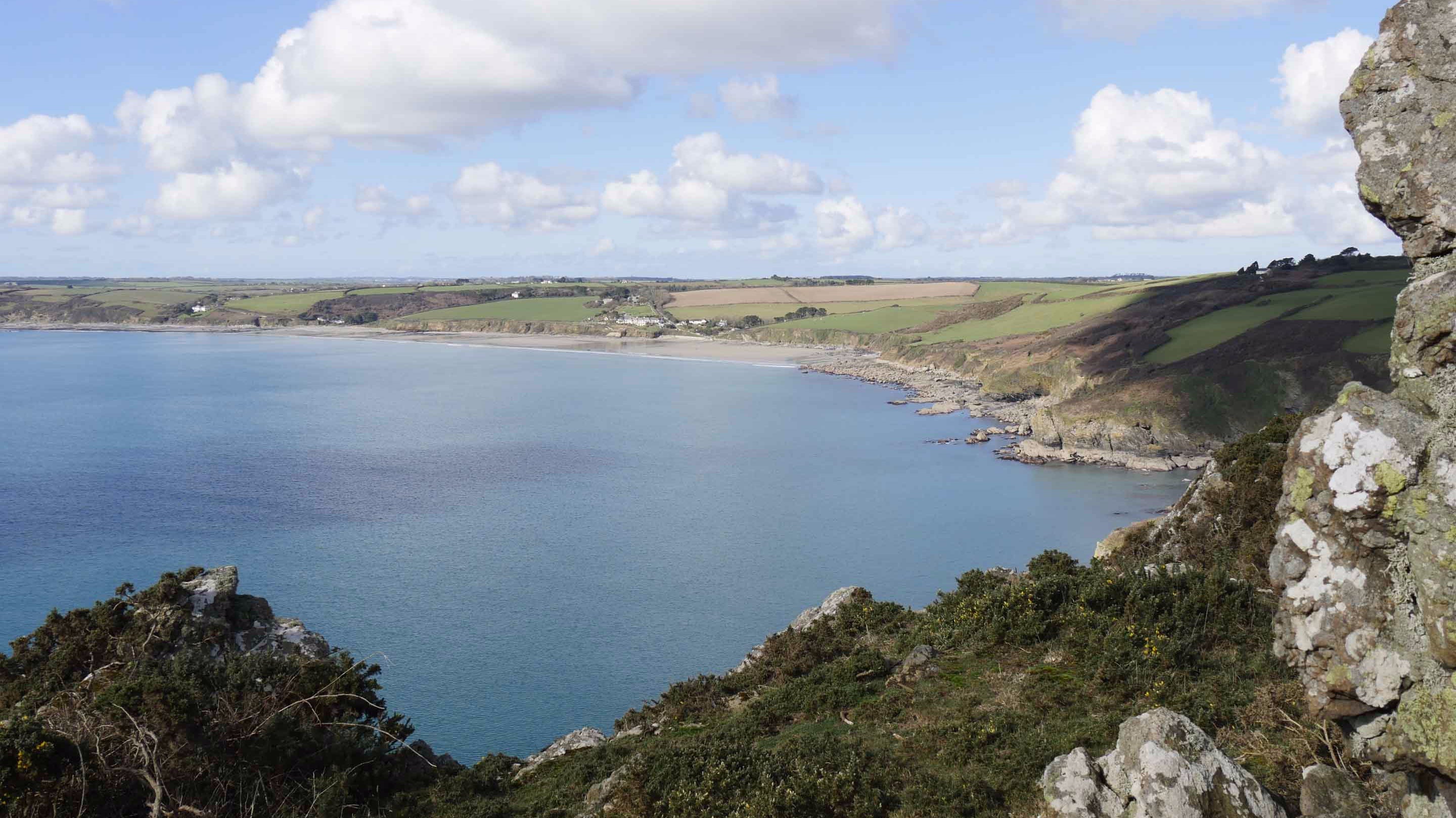 Elevated view from a cliff down towards Carne and Pendower beaches at Roseland, Cornwall