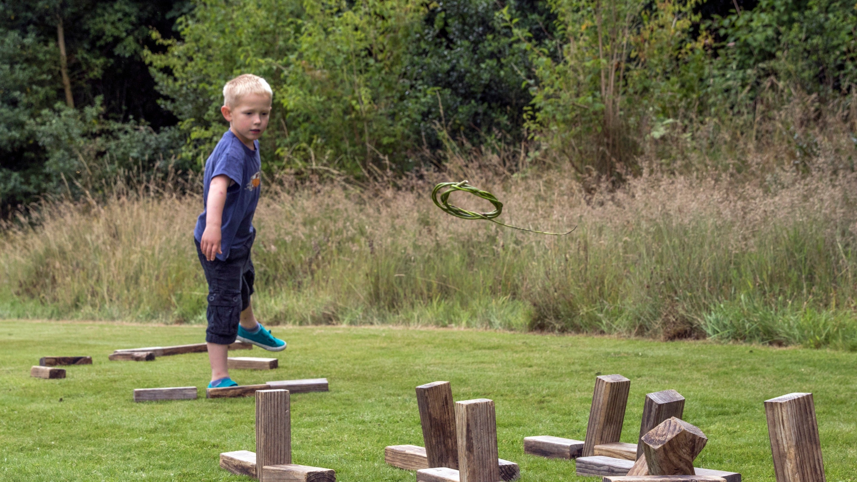 Child taking part in a game of quoits at Cotehele, Cornwall