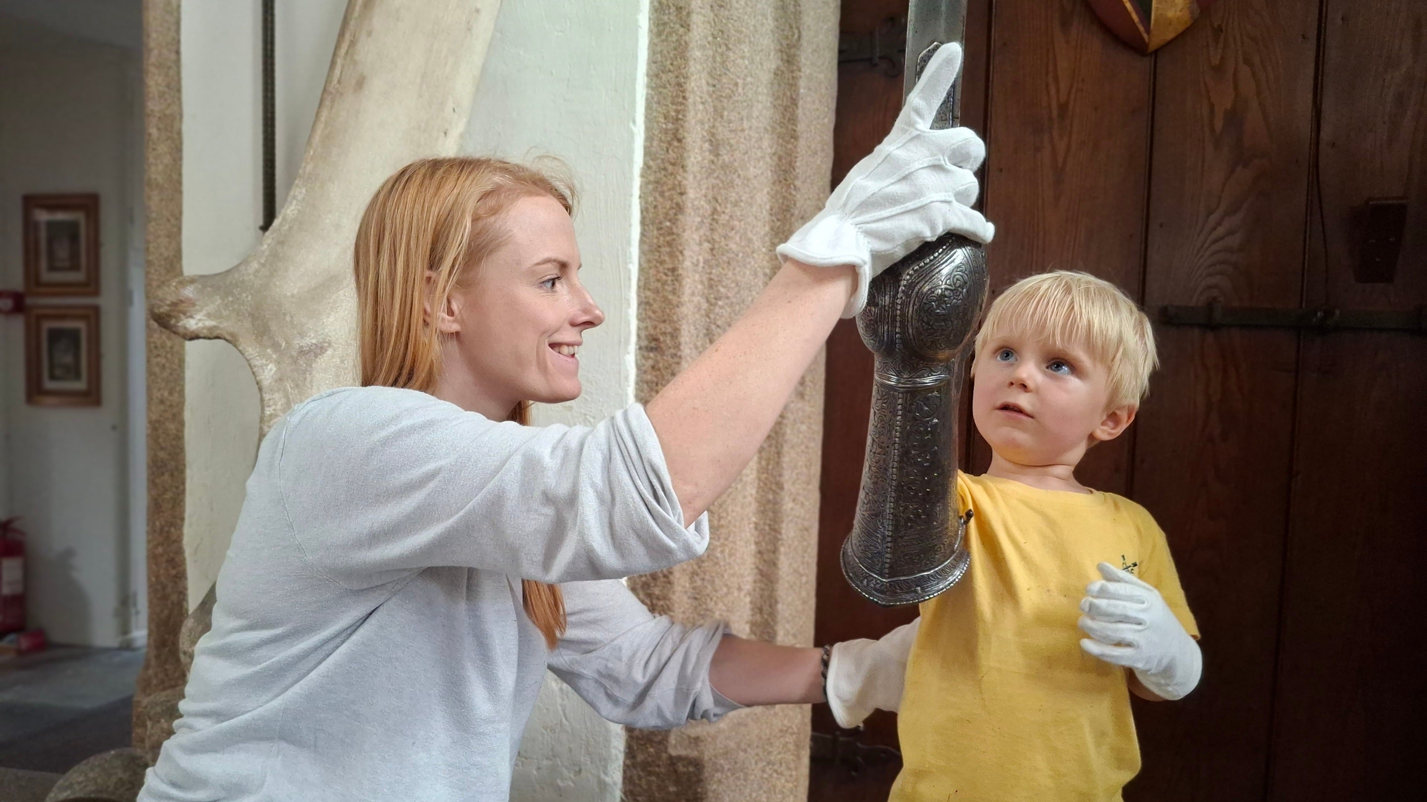 A child and a woman holding a metal sword