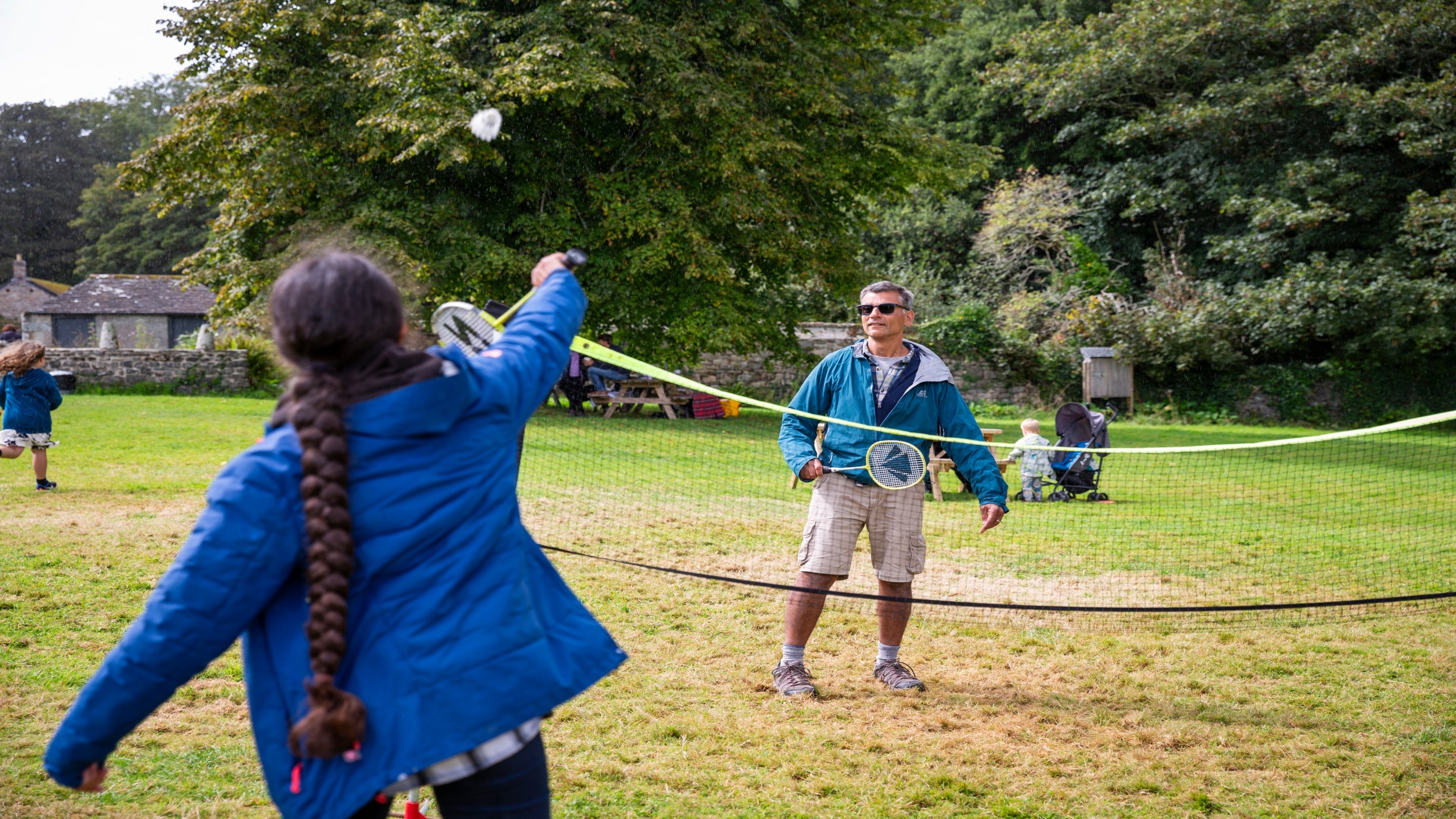 A family playing badminton in the garden at Godolphin