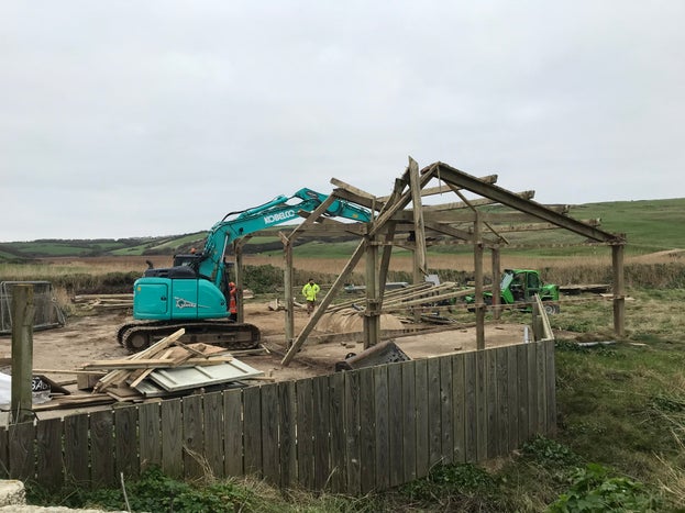 Work in Winnianton yard with small mechanical crane removing Gunwalloe barns opening up views