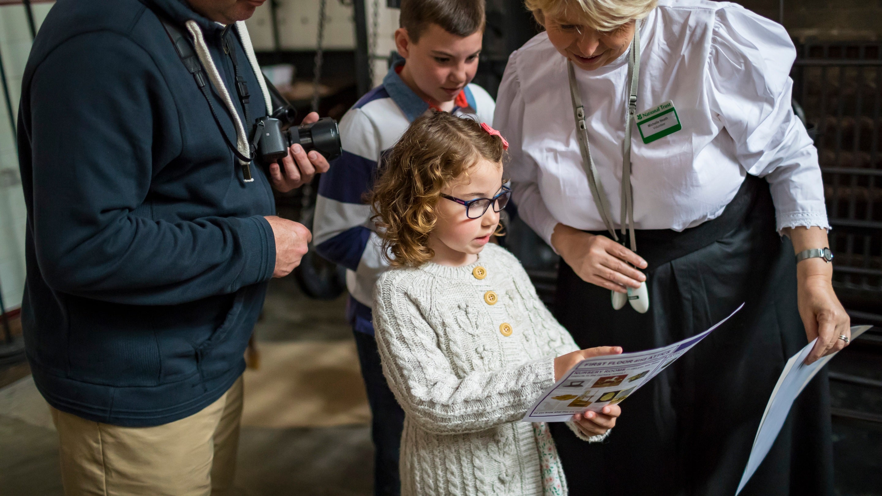 Family and volunteer room guide in the Victorian kitchen at Lanhydrock, Cornwall