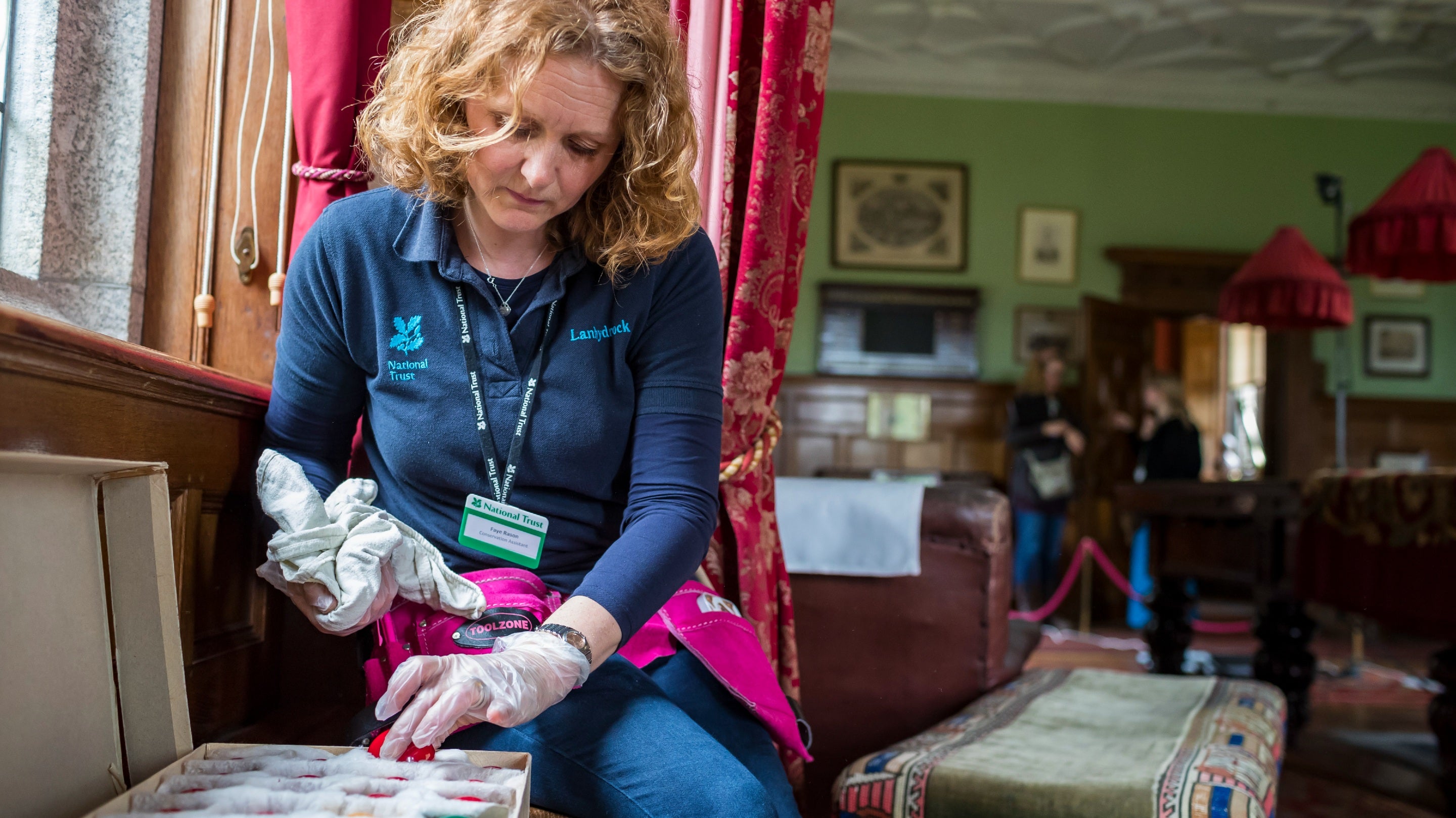 A woman cleans the collection at Lanhydrock in Cornwall