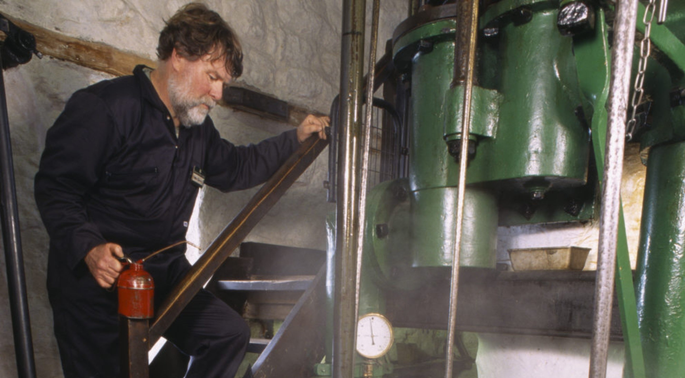 Chris Quick, a member of the 'Greasy Gang' volunteers, in the engine room of the Levant beam engine, St Just, Cornwall.