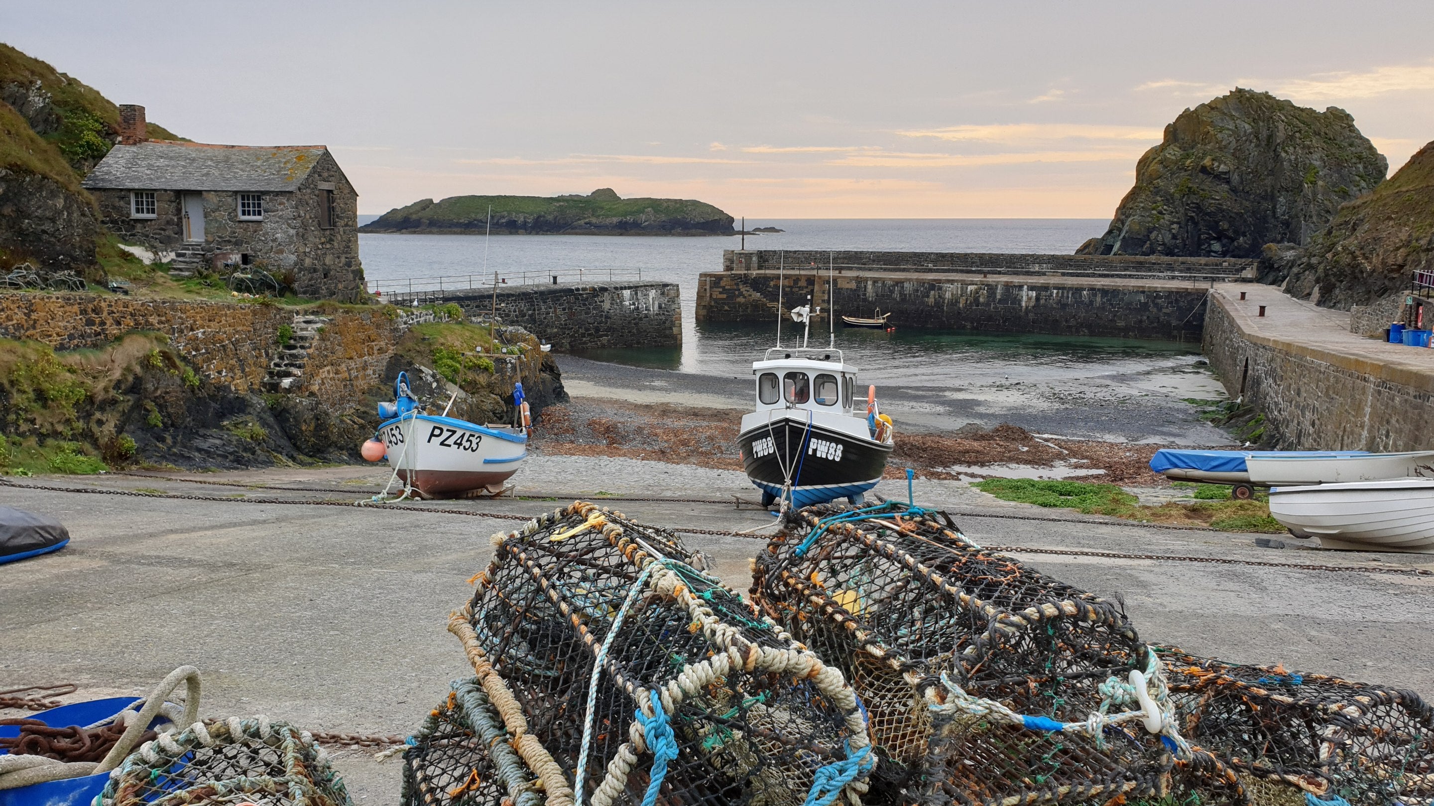 Fishing boats and lobster pots in the harbour in autumn at Mullion Cove, Cornwall