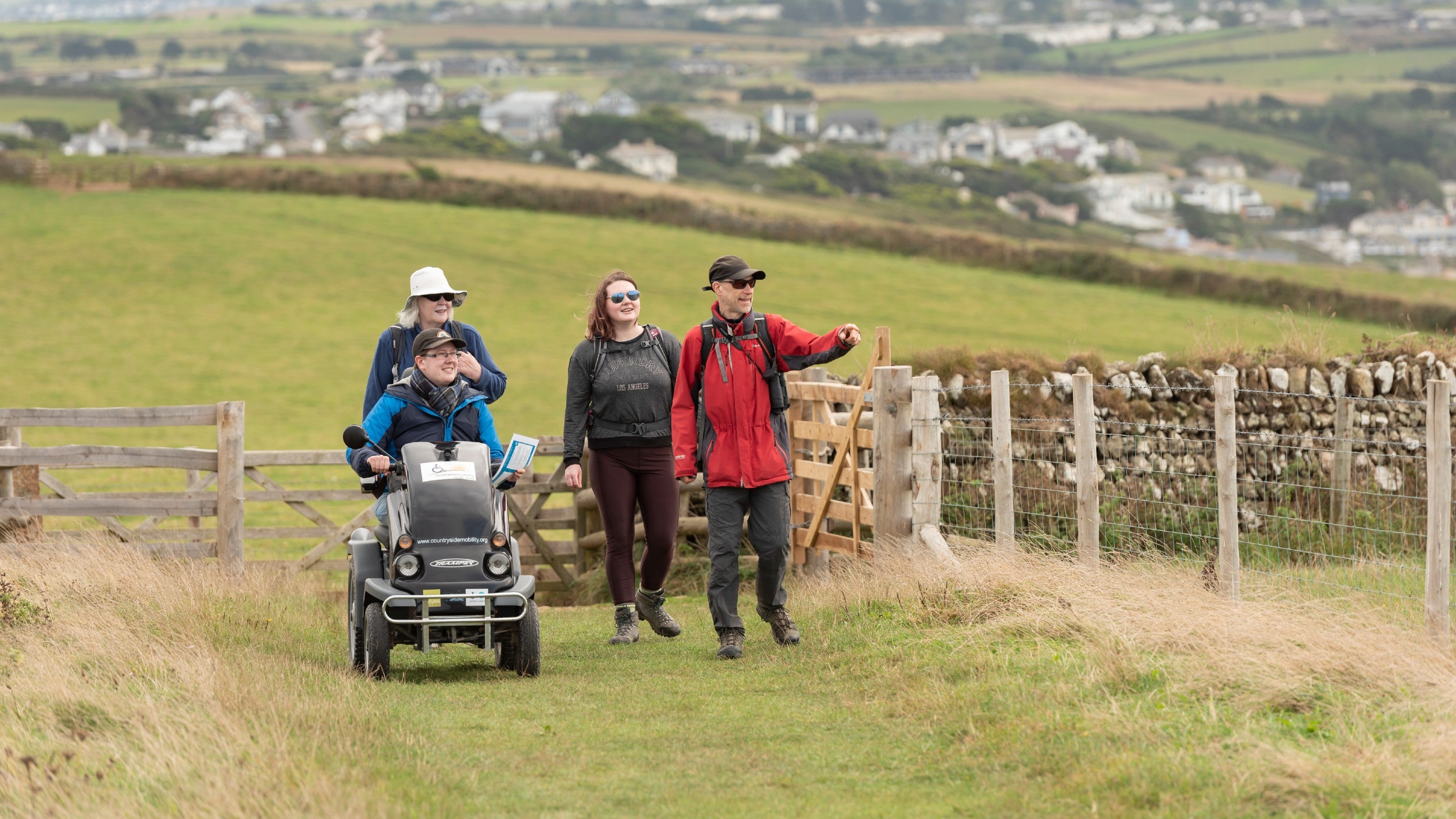 A group, with one using the Tramper mobility scooter, enjoying a visit to Pentire, Cornwall
